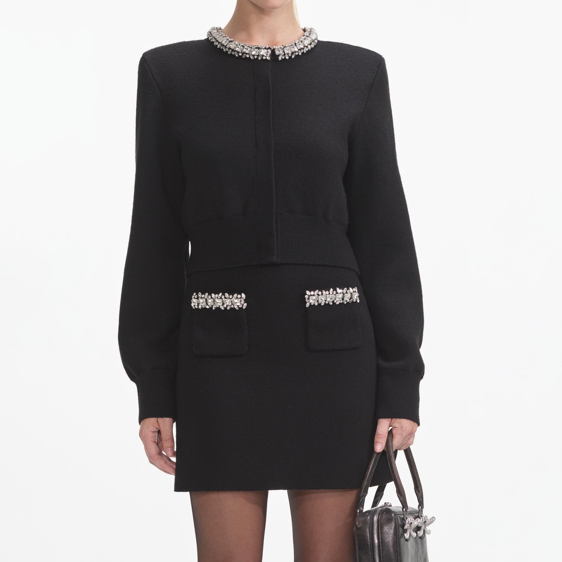 A close up of a woman wearing the Black Knit Embellished Mini Skirt