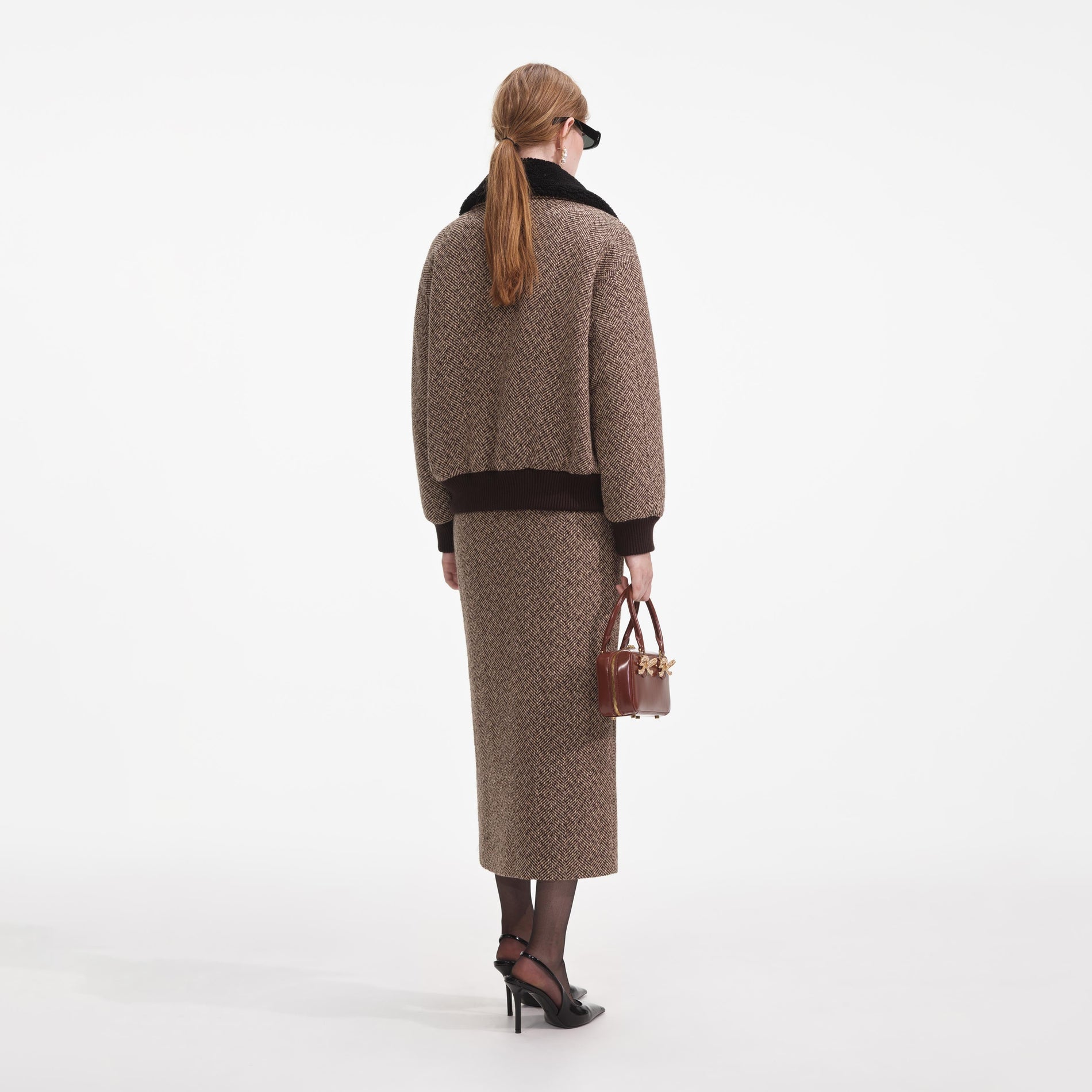 Back view of a woman wearing the Brown Herringbone Midi Skirt