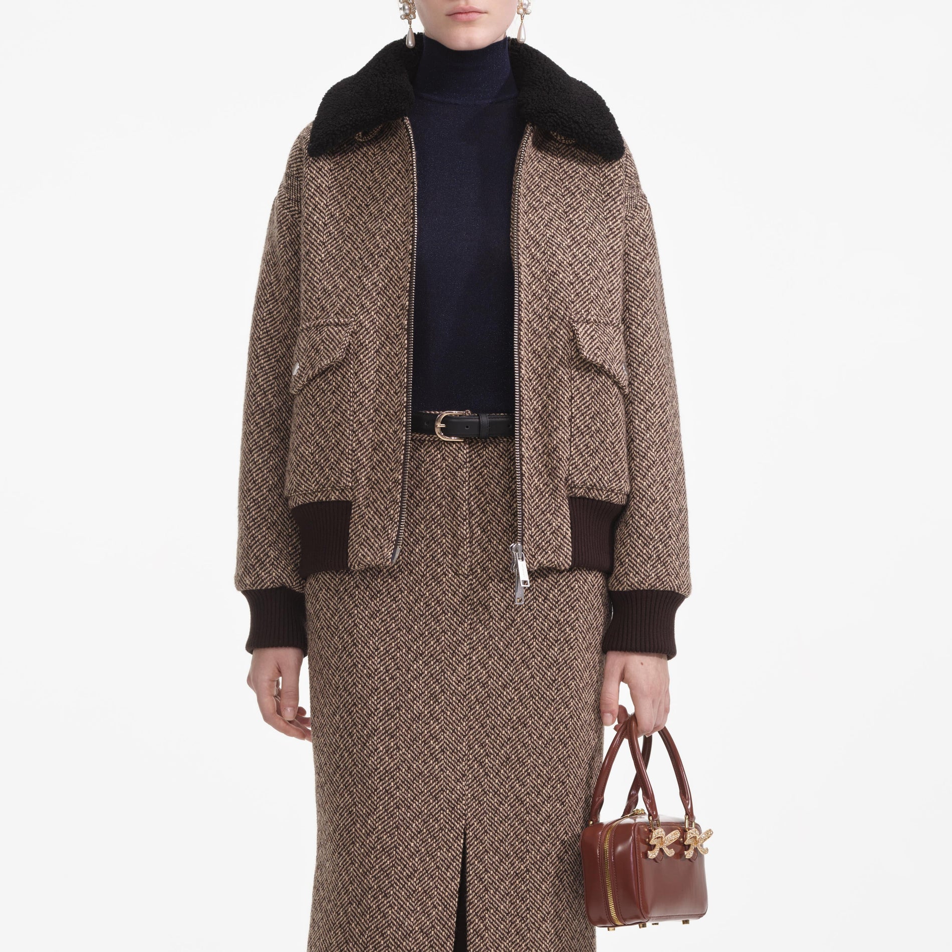 A close up of a woman wearing the Brown Herringbone Midi Skirt