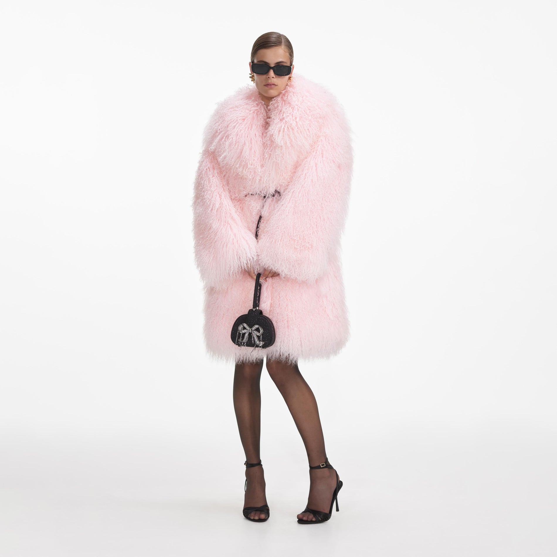 Side view of a woman wearing the Pink Shearling Coat
