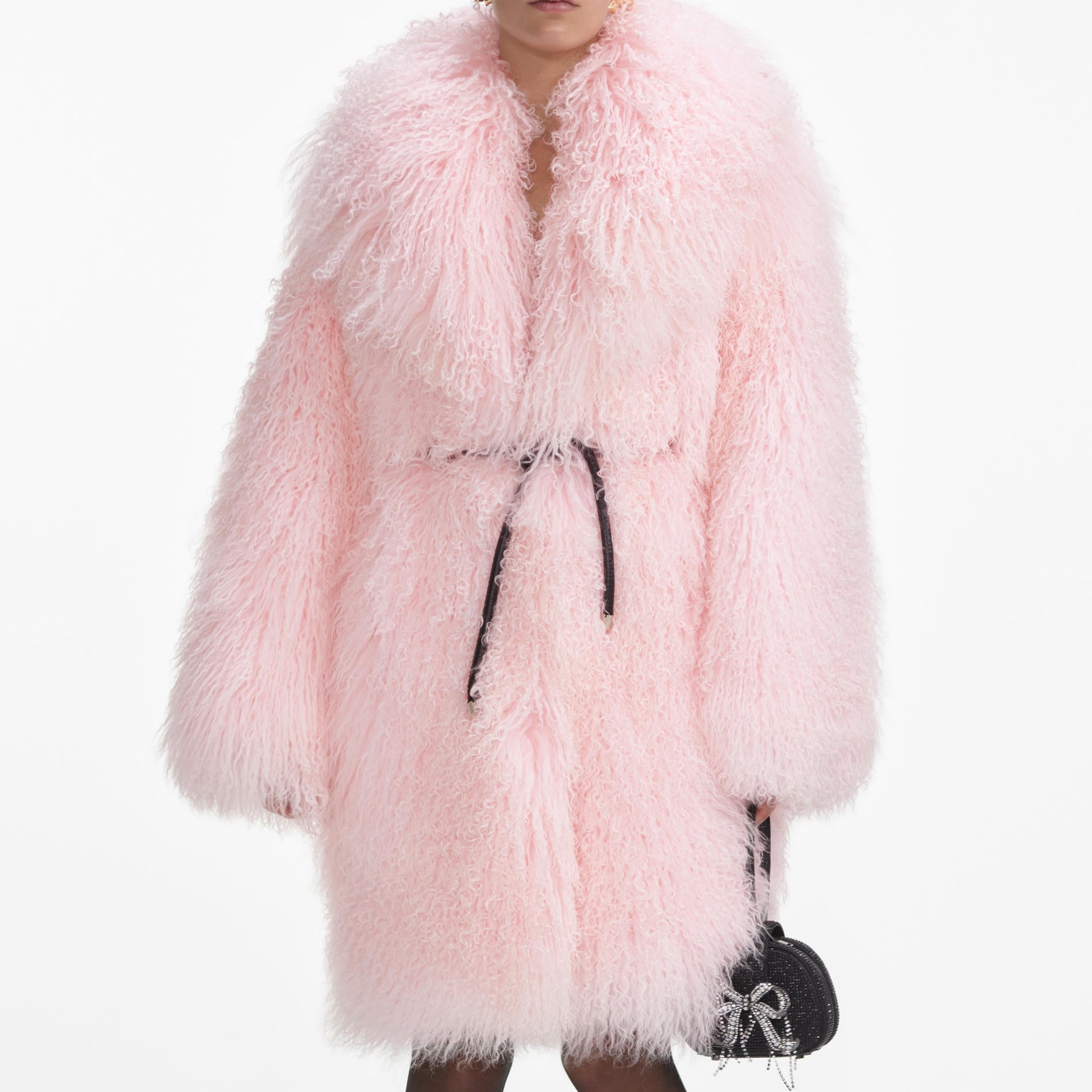 A close up of a woman wearing the Pink Shearling Coat