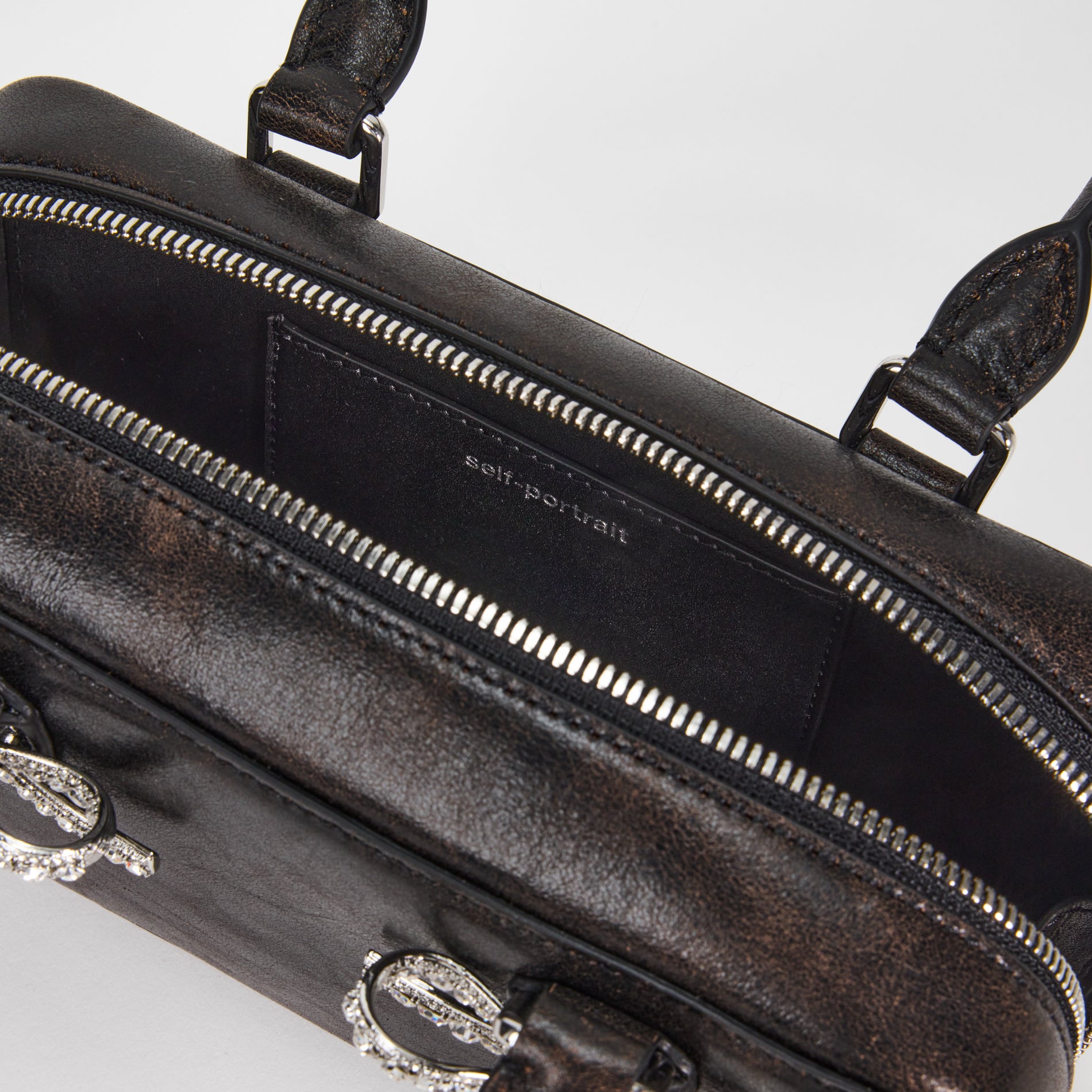 A close up of a woman wearing the Black Distressed Leather Mini Tote Bag