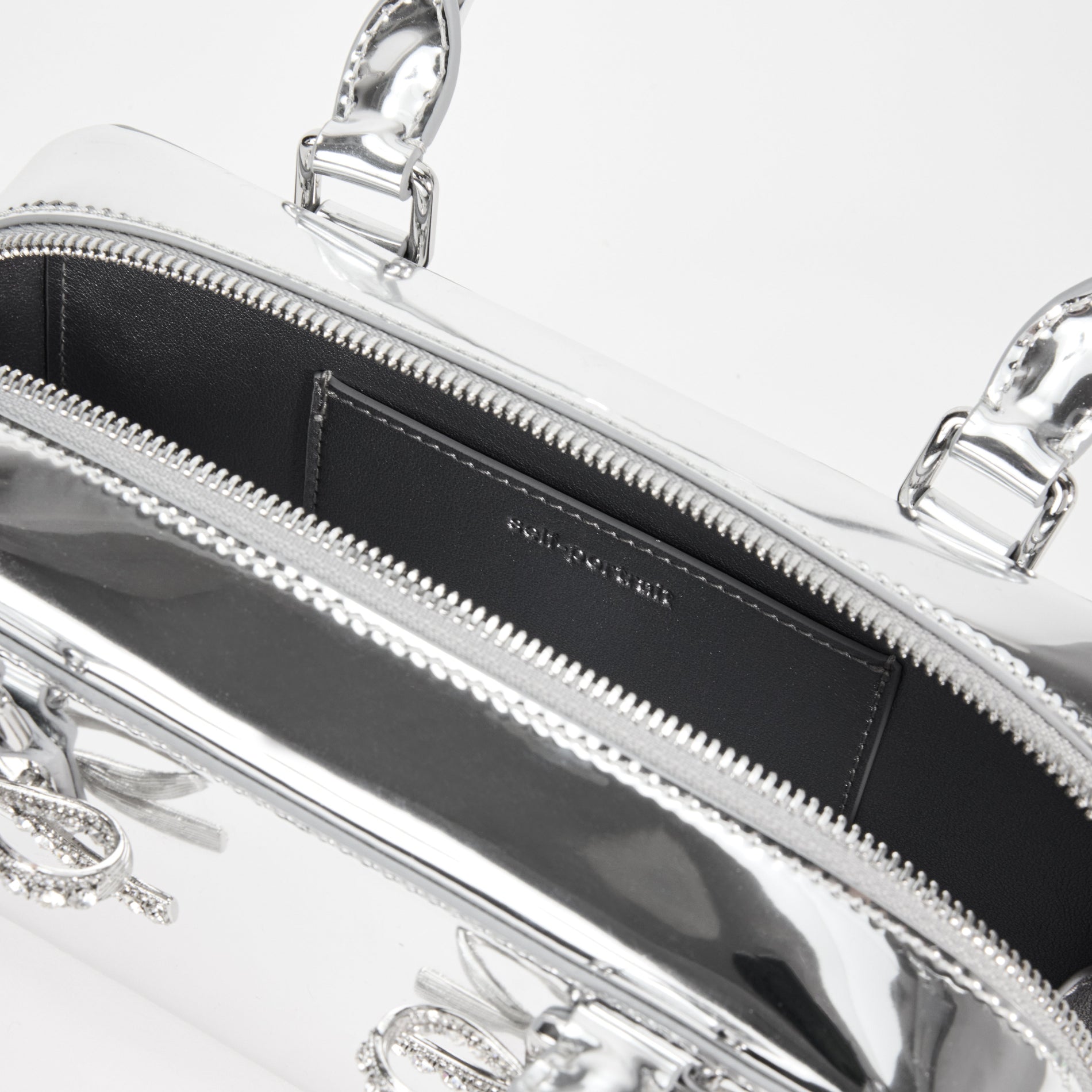 A close up of a woman wearing the Metallic Silver Leather Mini Tote Bag