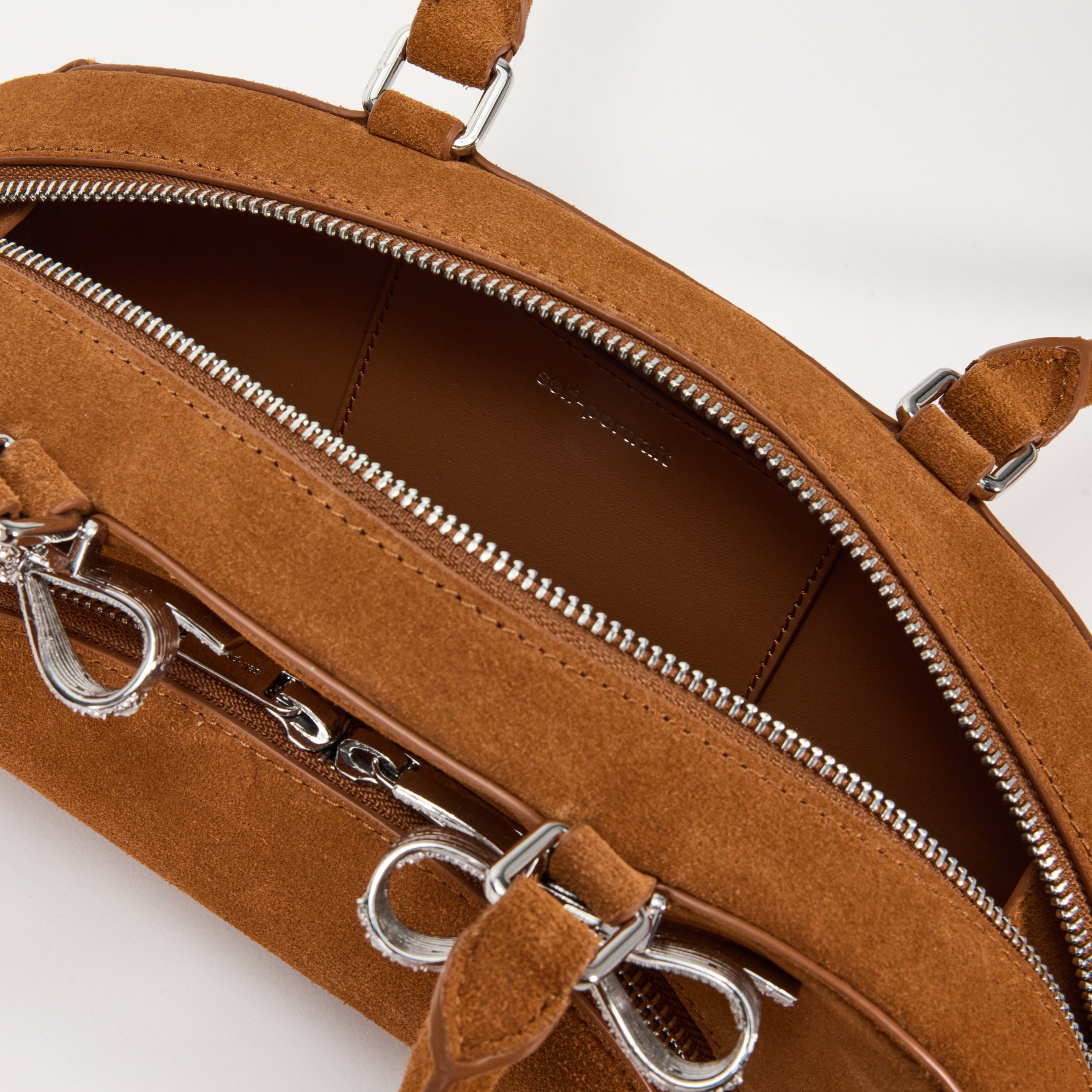 A close up of a woman wearing the Brown Suede Curved Shoulder Bag