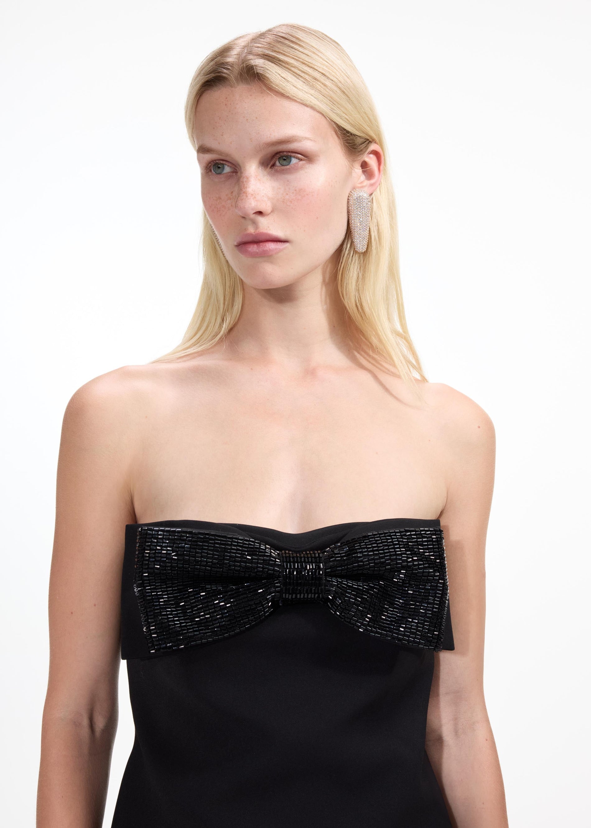 A close up of a woman wearing the Gold Crystal Bar Earrings