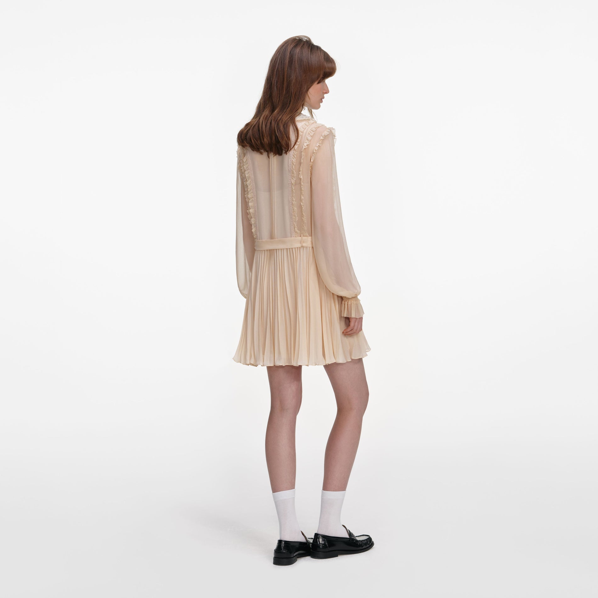 Back view of a woman wearing the Tan Pleated Georgette Mini Dress