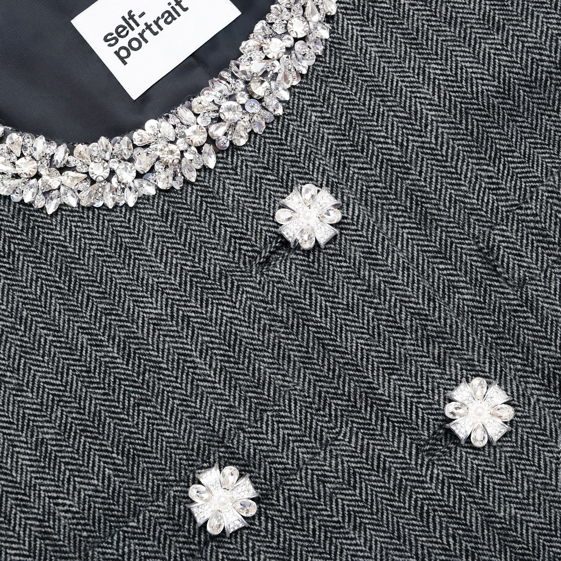 Side view of a woman wearing the Grey Herringbone Crystal Trim Jacket