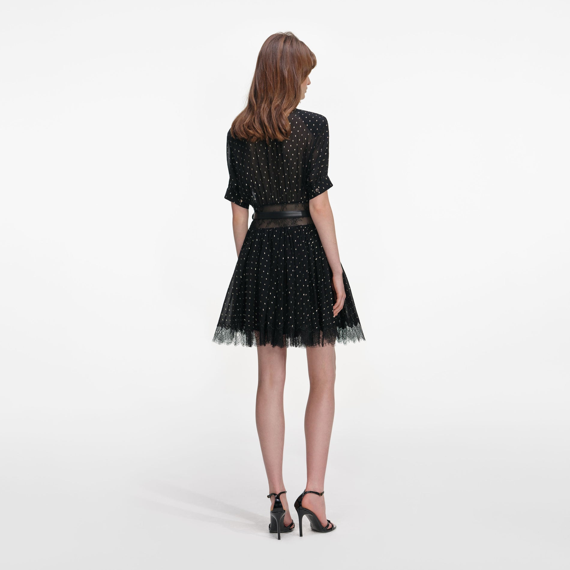 Back view of a woman wearing the Black And Gold Chiffon Mini Dress