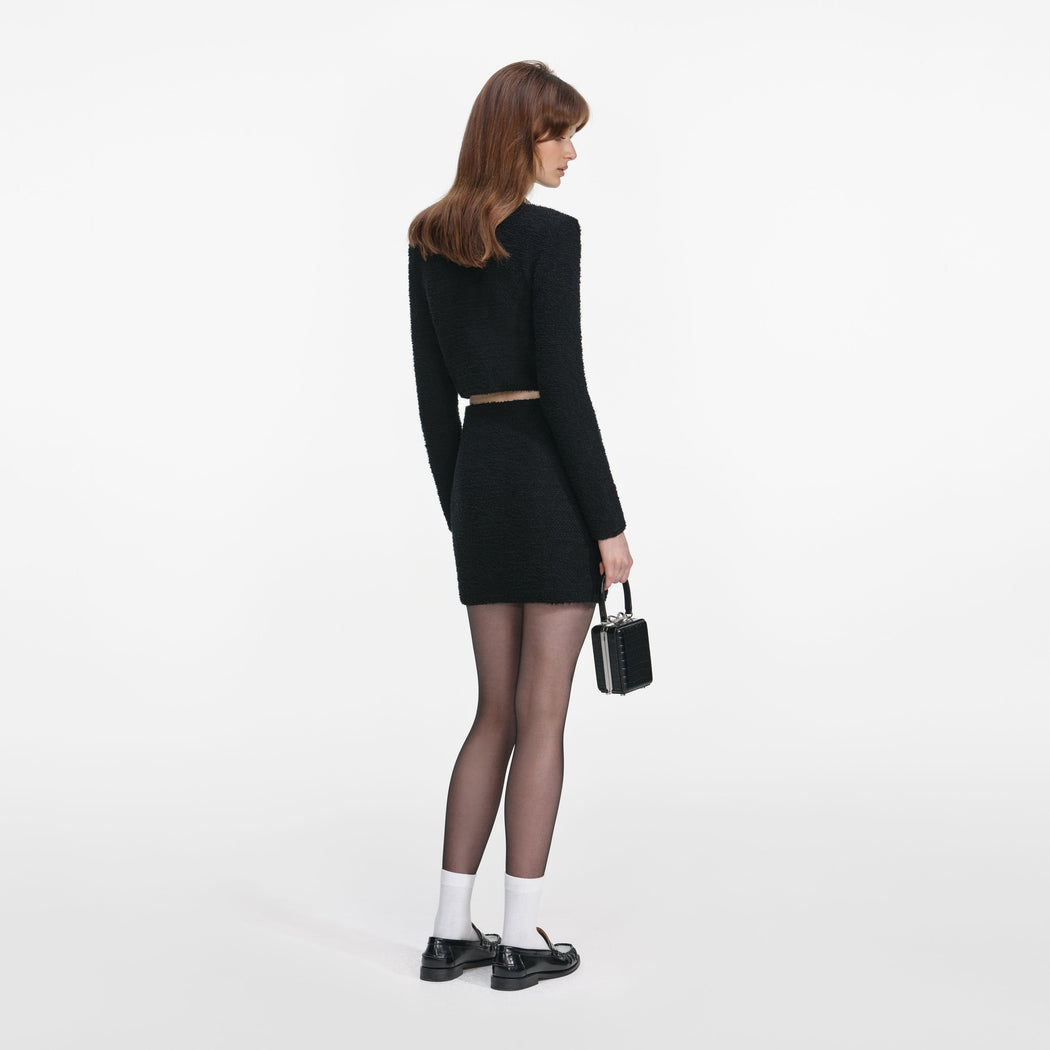 Back view of a woman wearing the Black Knit Mini Skirt