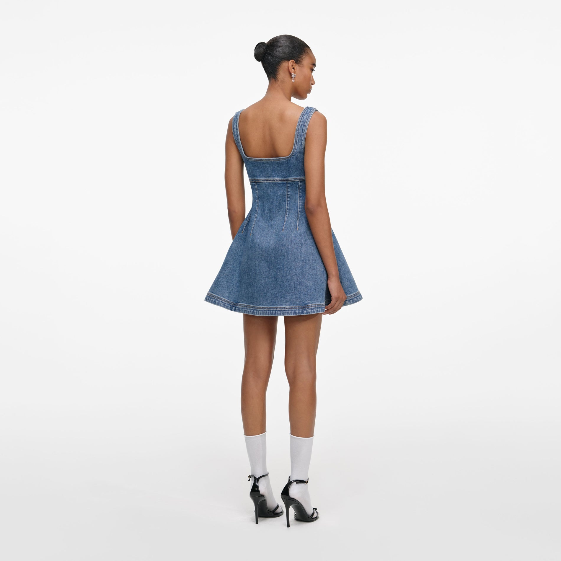 Back view of a woman wearing the Denim Flared Logo Mini Dress