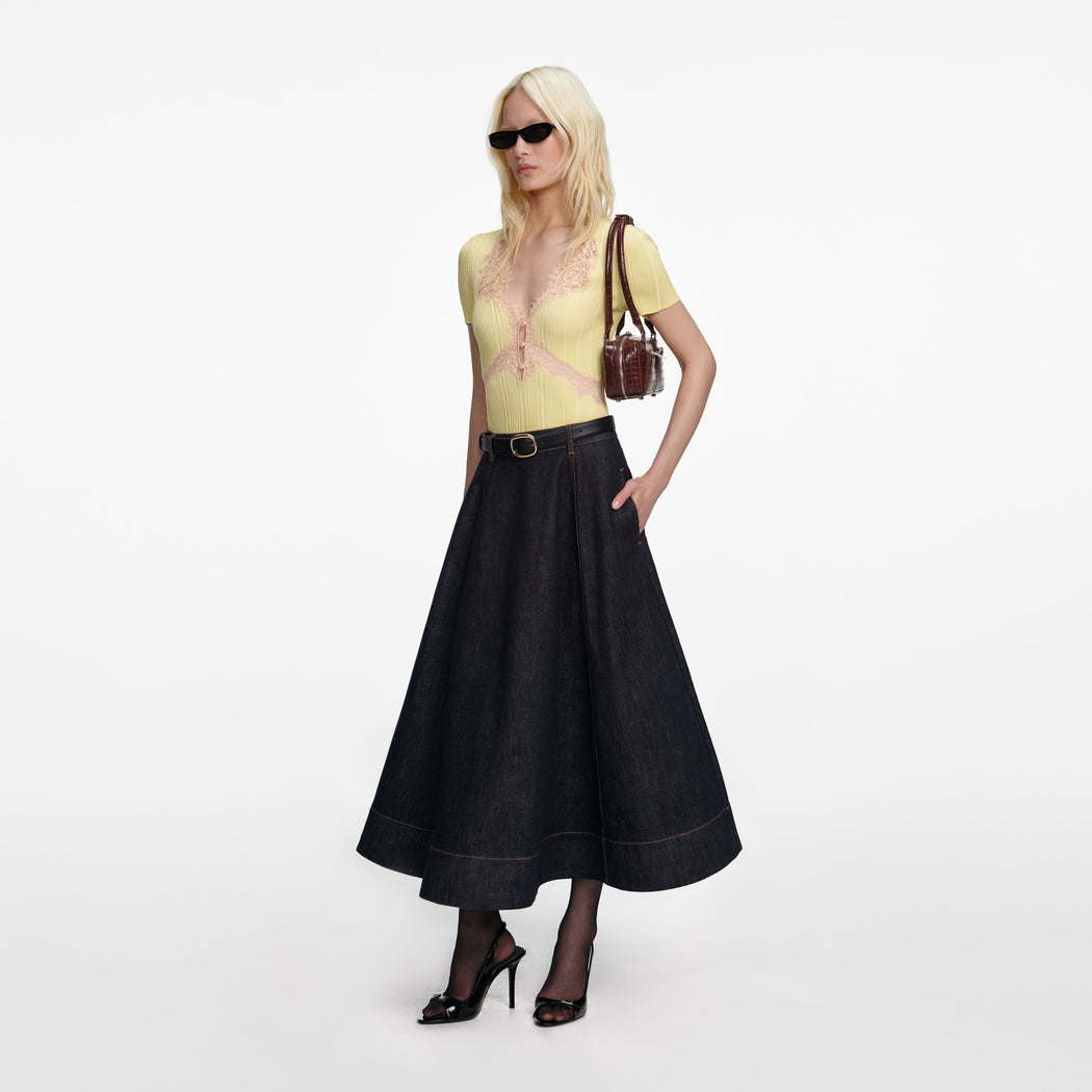 Side view of a woman wearing the Indigo Denim Flared Midi Skirt