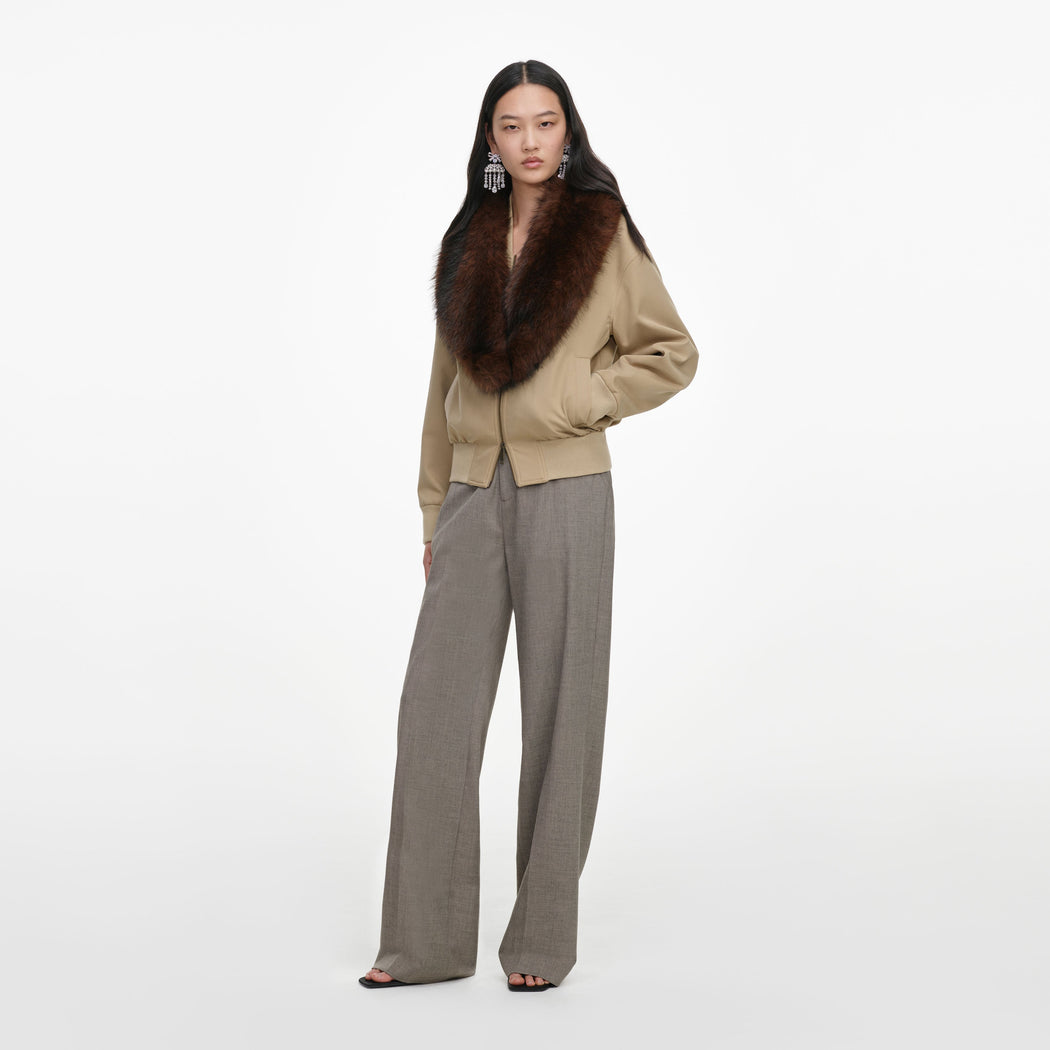 Side view of a woman wearing the Beige Faux Fur Bomber Jacket