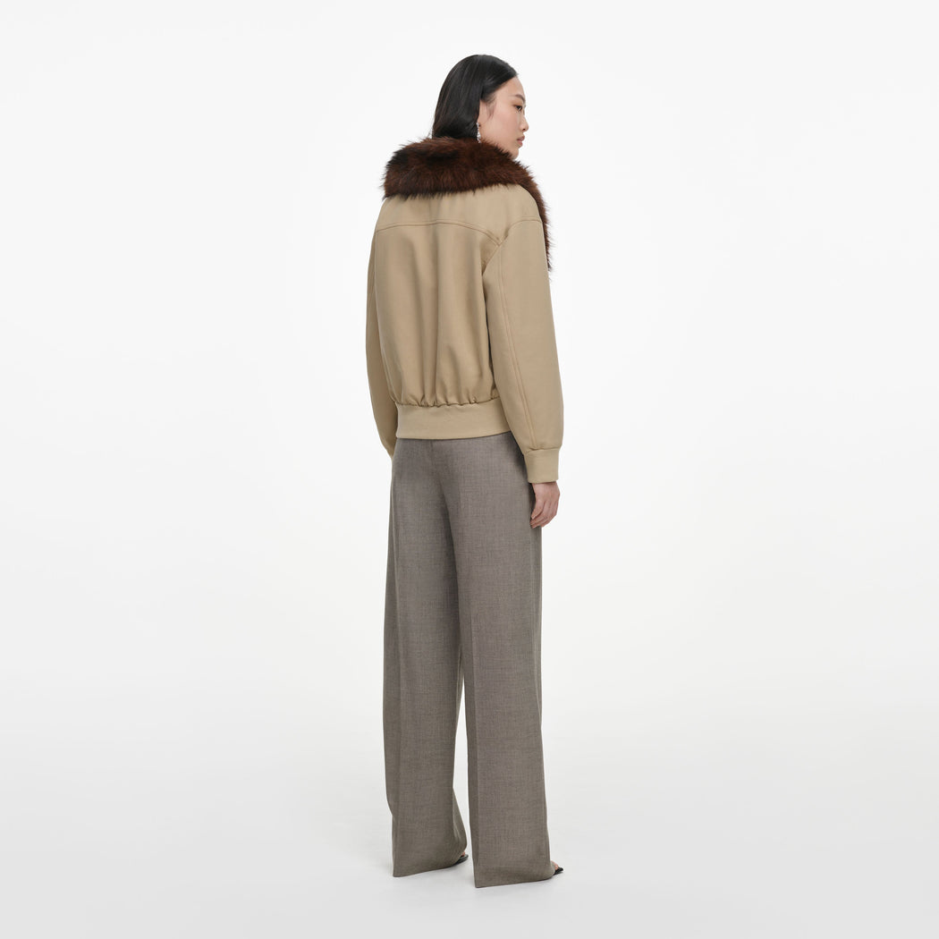 Back view of a woman wearing the Beige Faux Fur Bomber Jacket