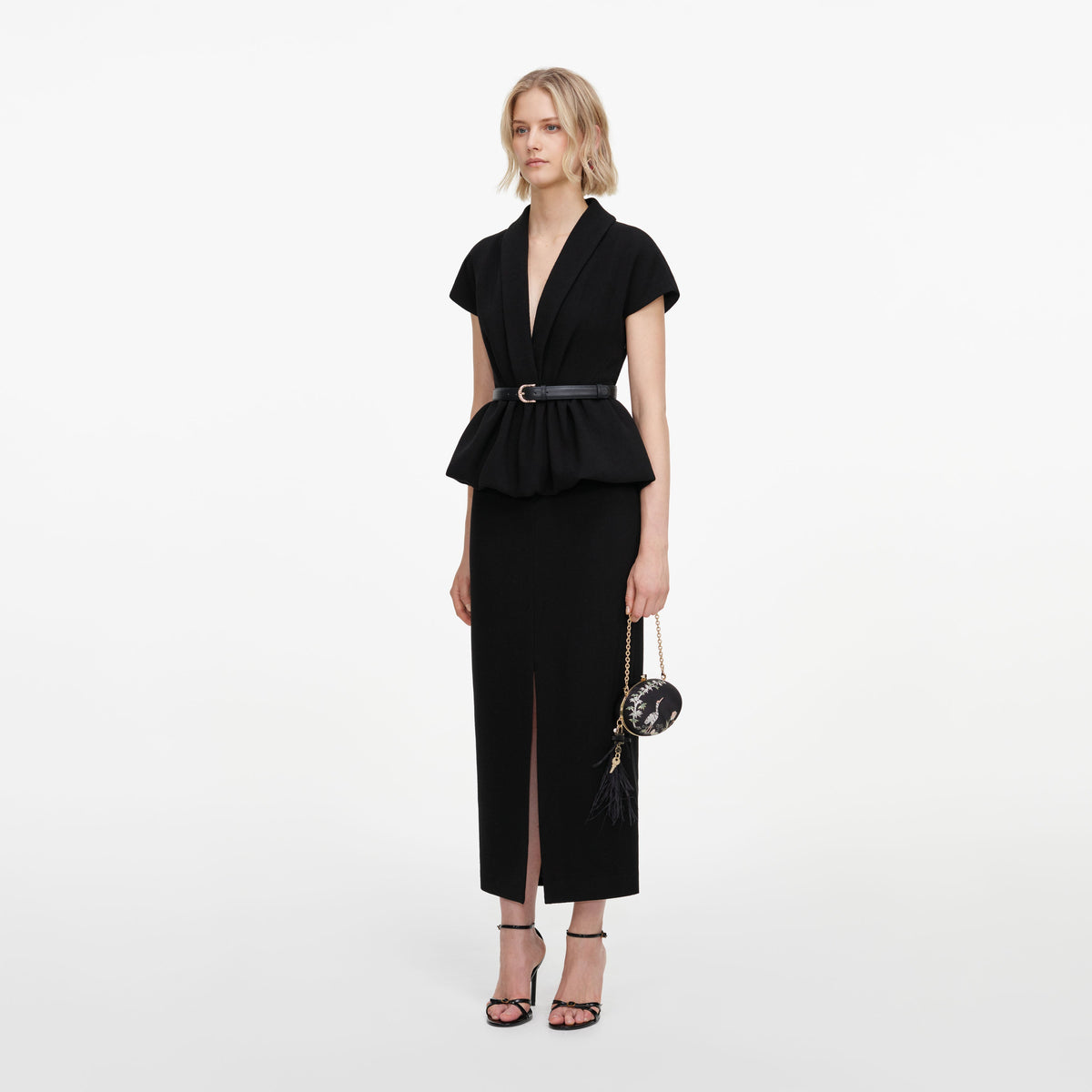 Side view of a woman wearing the Black Crepe Peplum Midi Dress