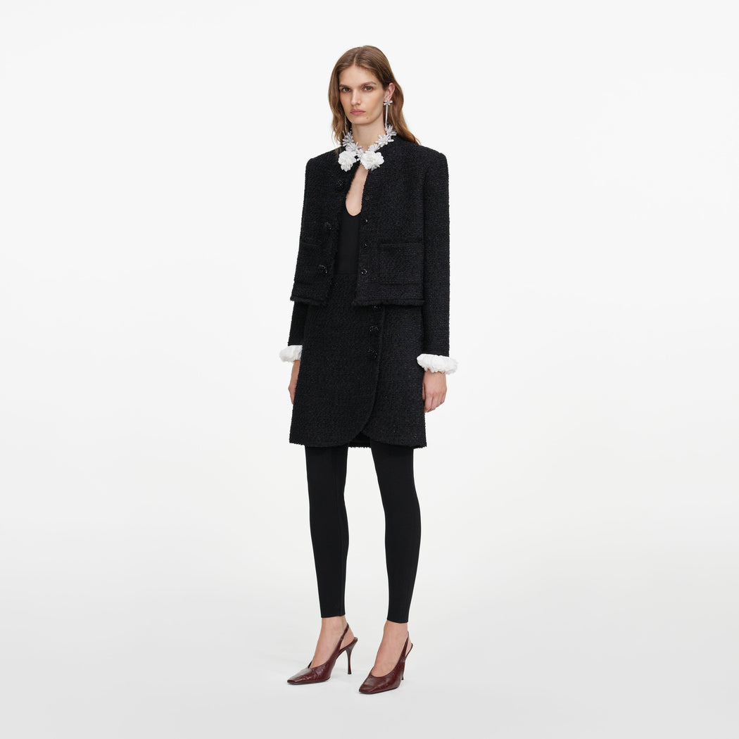 Side view of a woman wearing the Black Boucle Flower Jacket