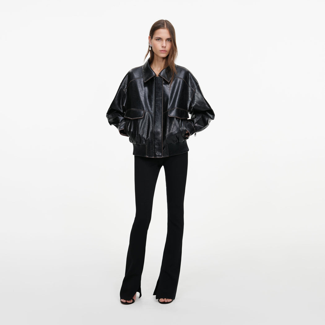 A close up of a woman wearing the Black Oversized Faux Leather Jacket