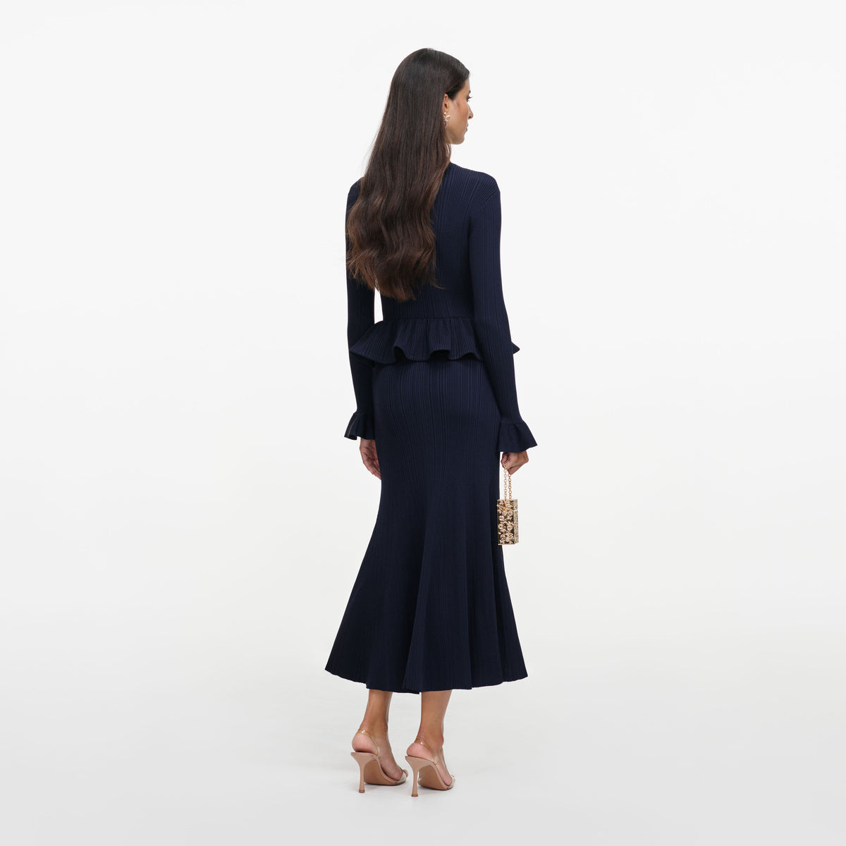 Back view of a woman wearing the Navy Peplum Knit Midi Dress