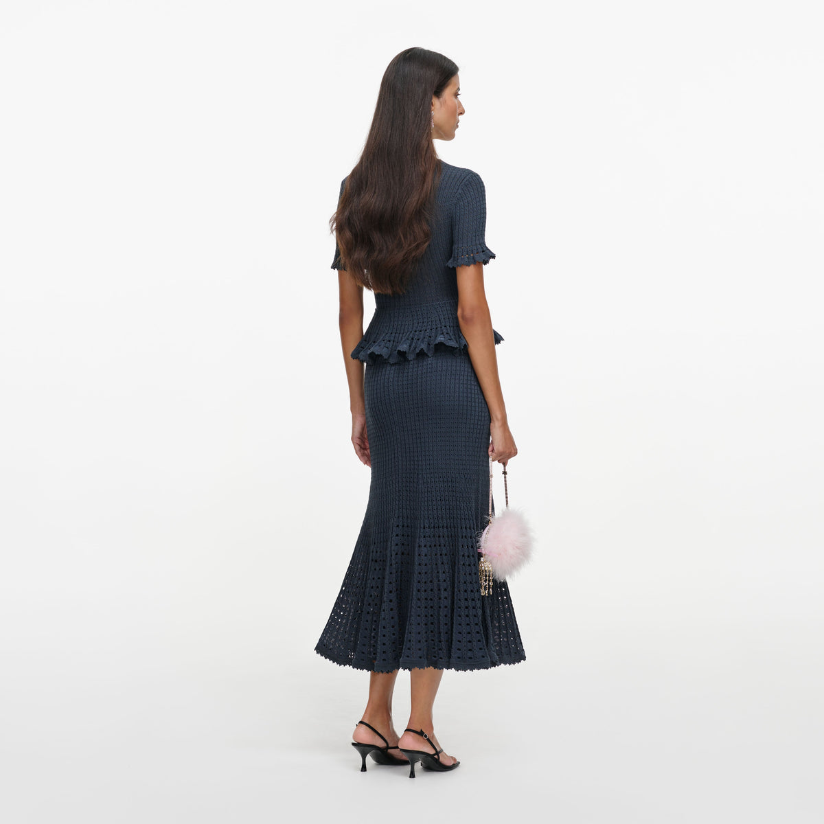 Back view of a woman wearing the Grey Pointelle Peplum Knit Midi Dress