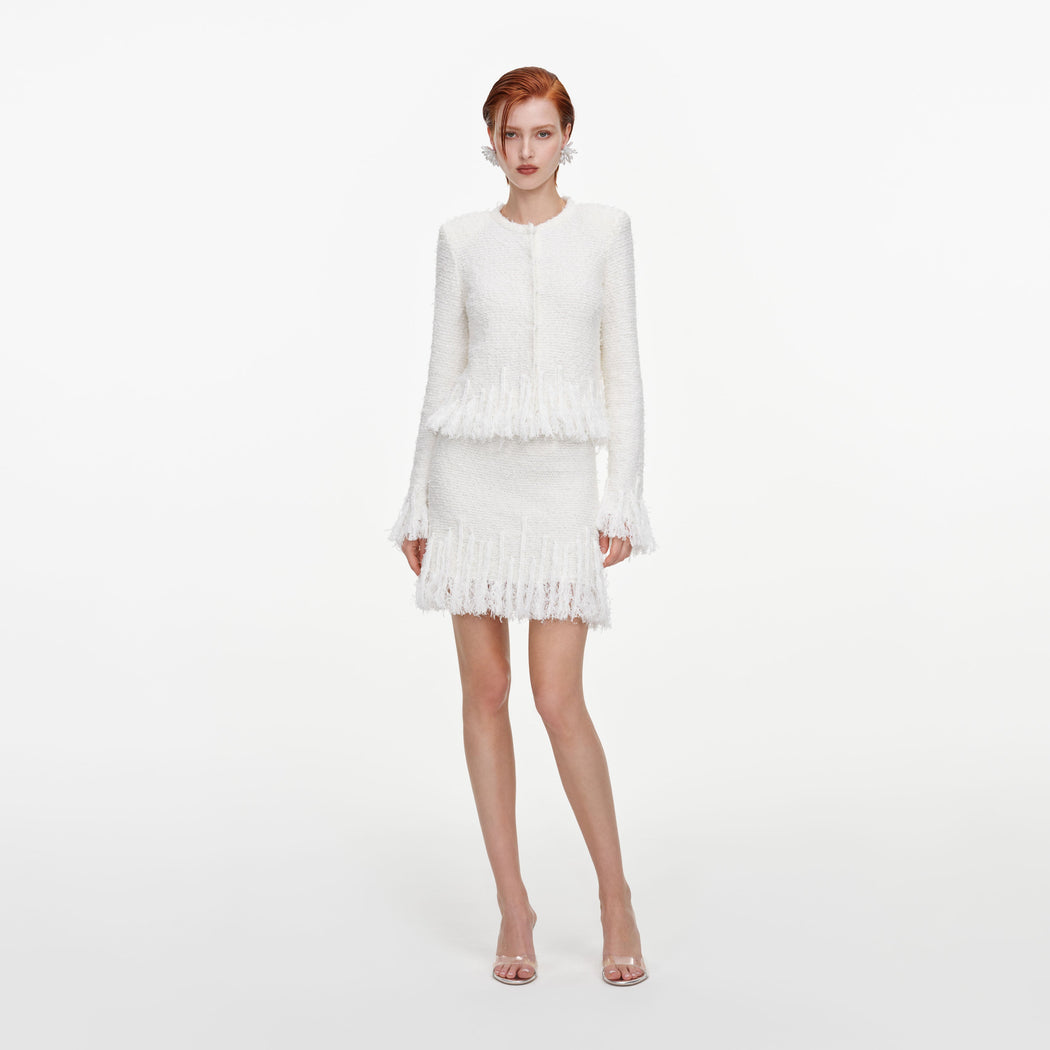 Front view of a woman wearing the White Fringe Knit Mini Skirt