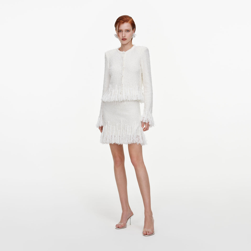Side view of a woman wearing the White Fringe Knit Mini Skirt