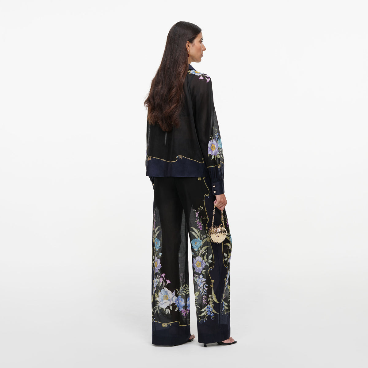 Back view of a woman wearing the Navy Floral Organza Trousers