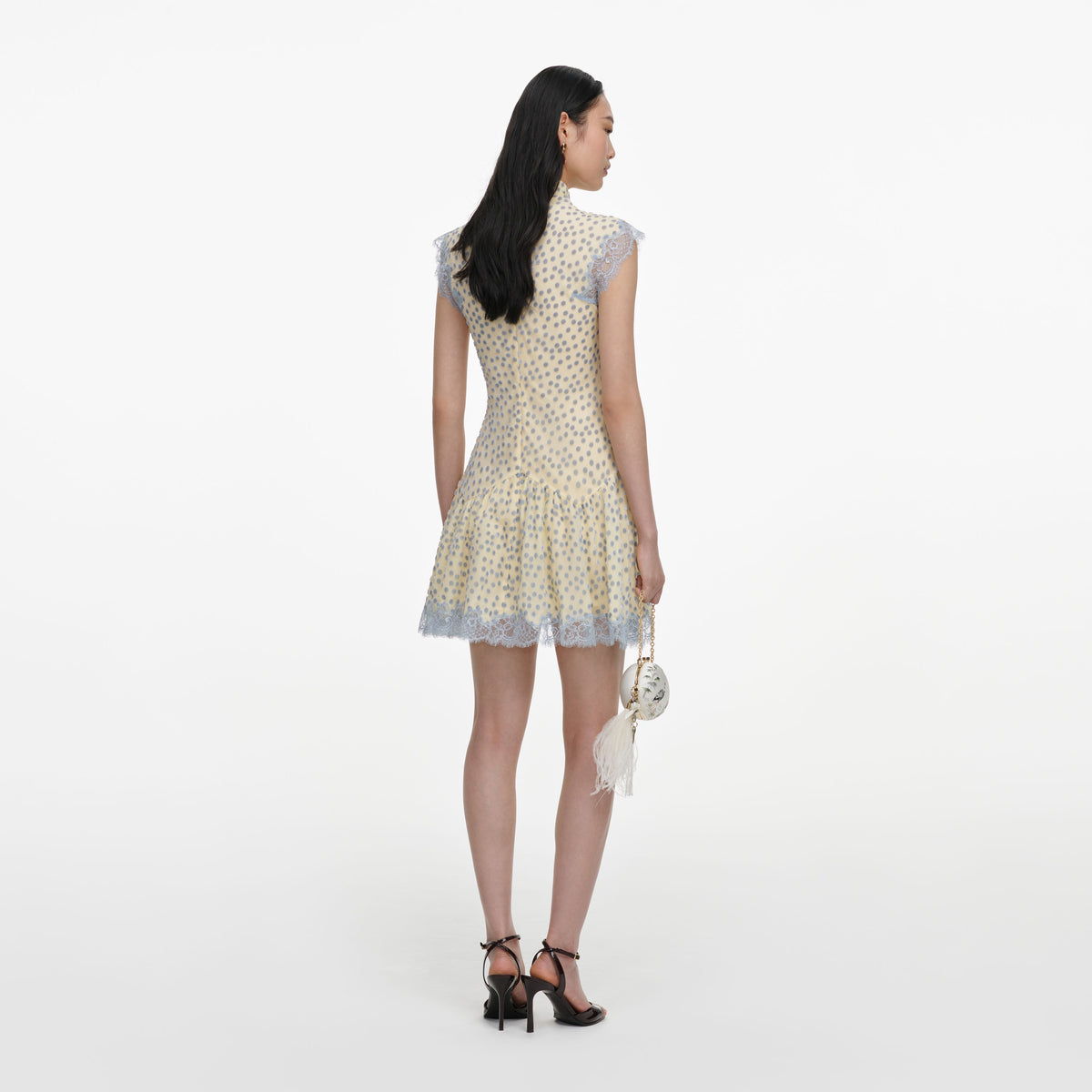 Back view of a woman wearing the Yellow Devore Polka Dot Mini Dress