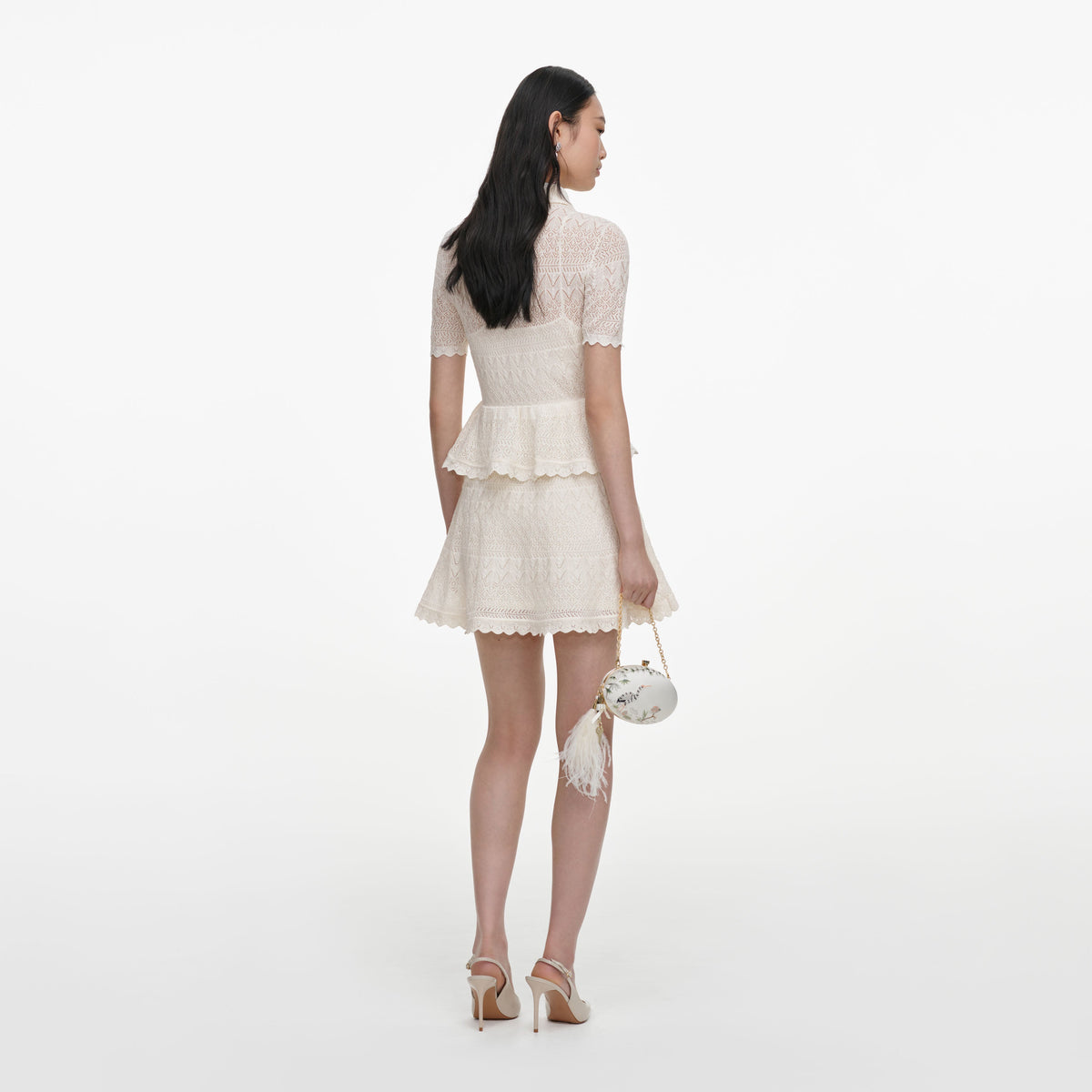 Back view of a woman wearing the Cream Pointelle Knit Wrap Peplum Dress