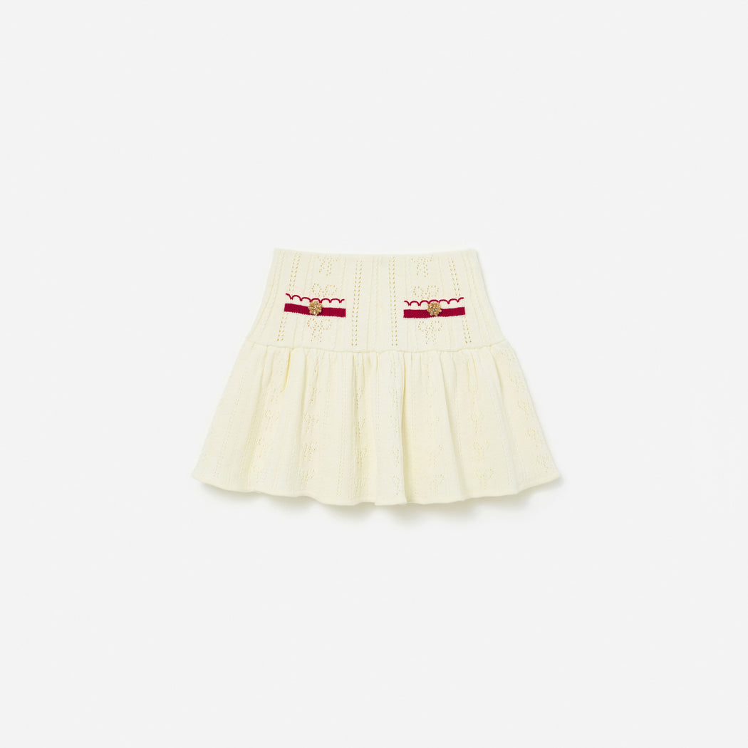 Front view of a girl wearing the Cream Pointelle Knit Stripe Skirt
