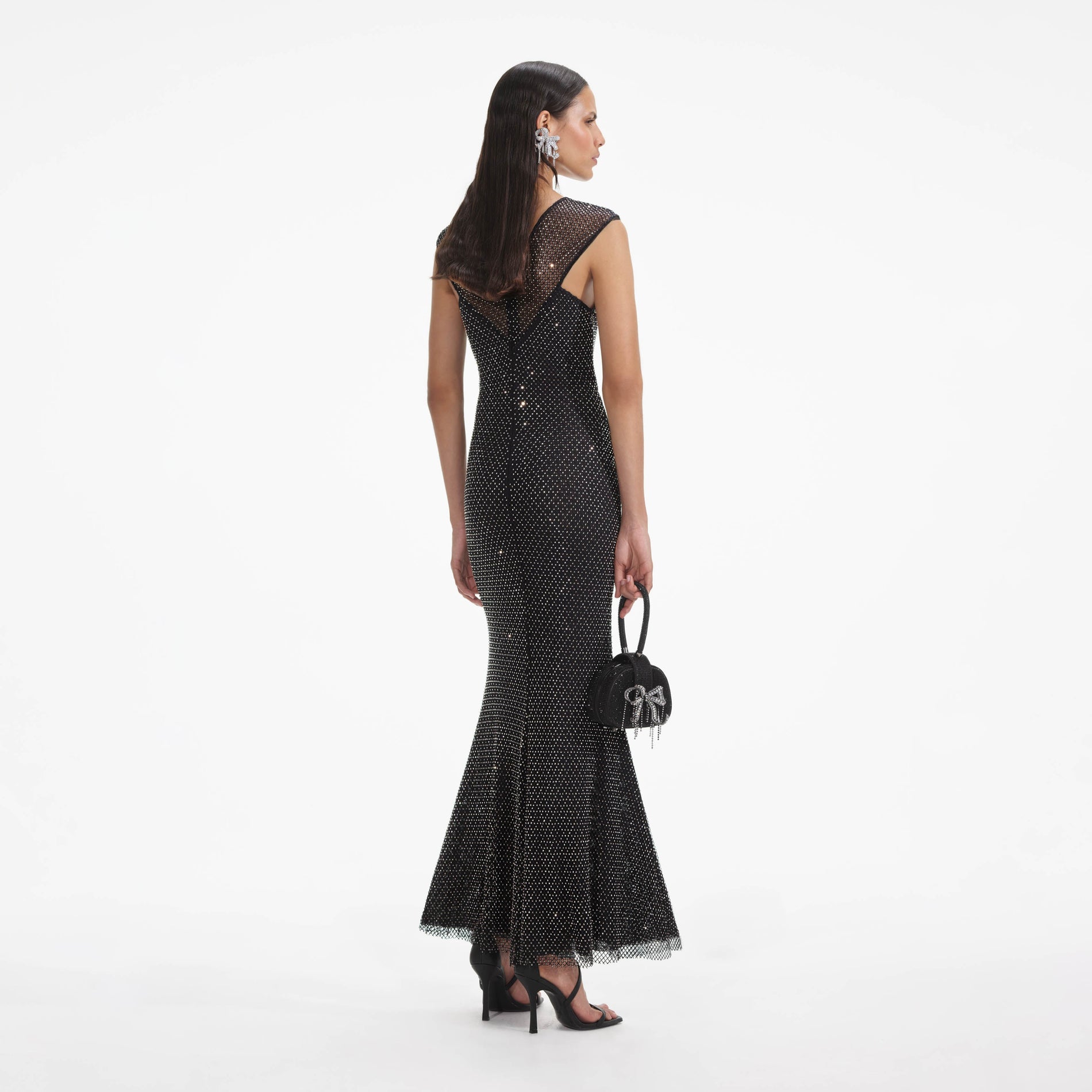 Side view of a woman wearing the Black Rhinestone Fishnet Crossover Midi Dress