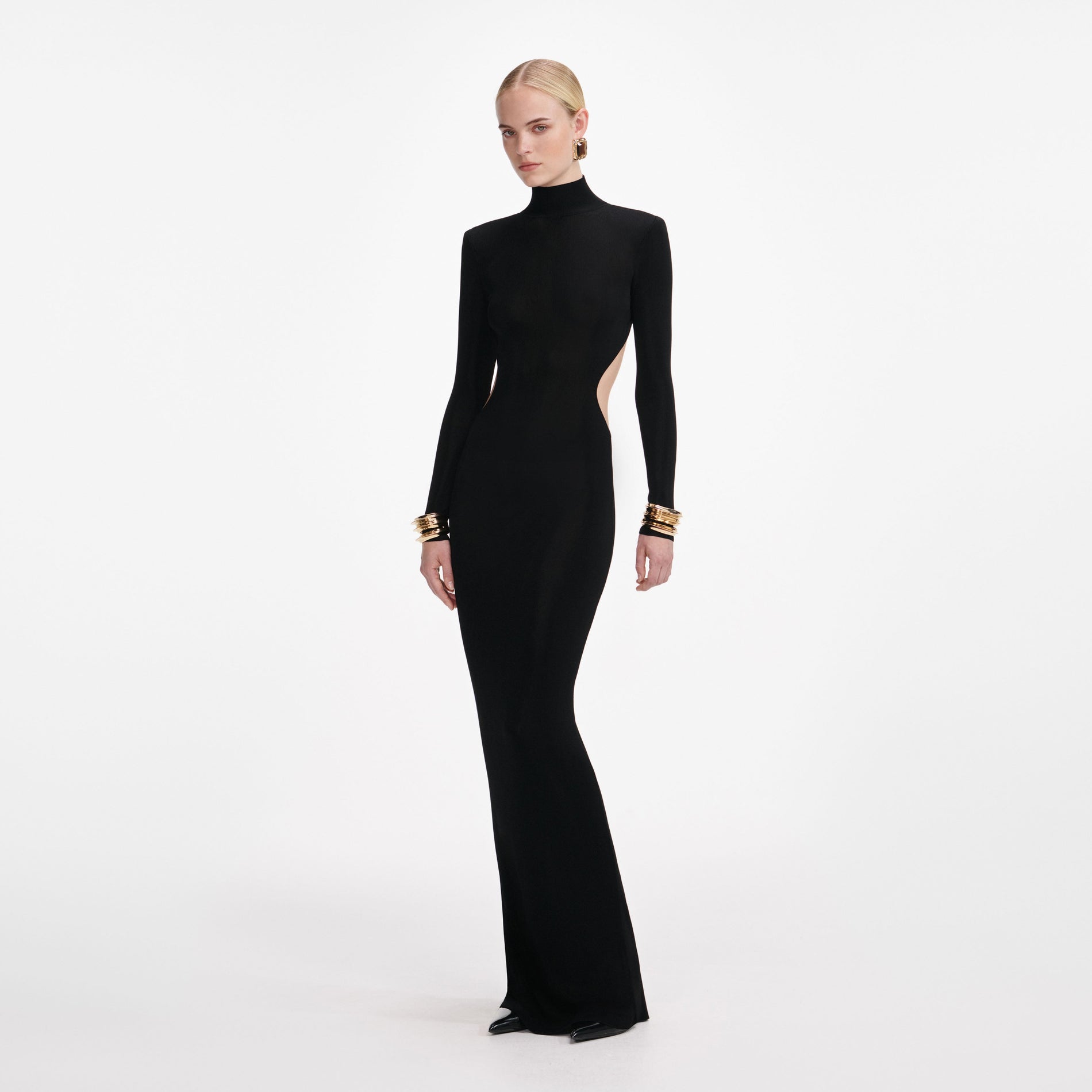 Side view of a woman wearing the Black Viscose Knit Cut Out Maxi Dress