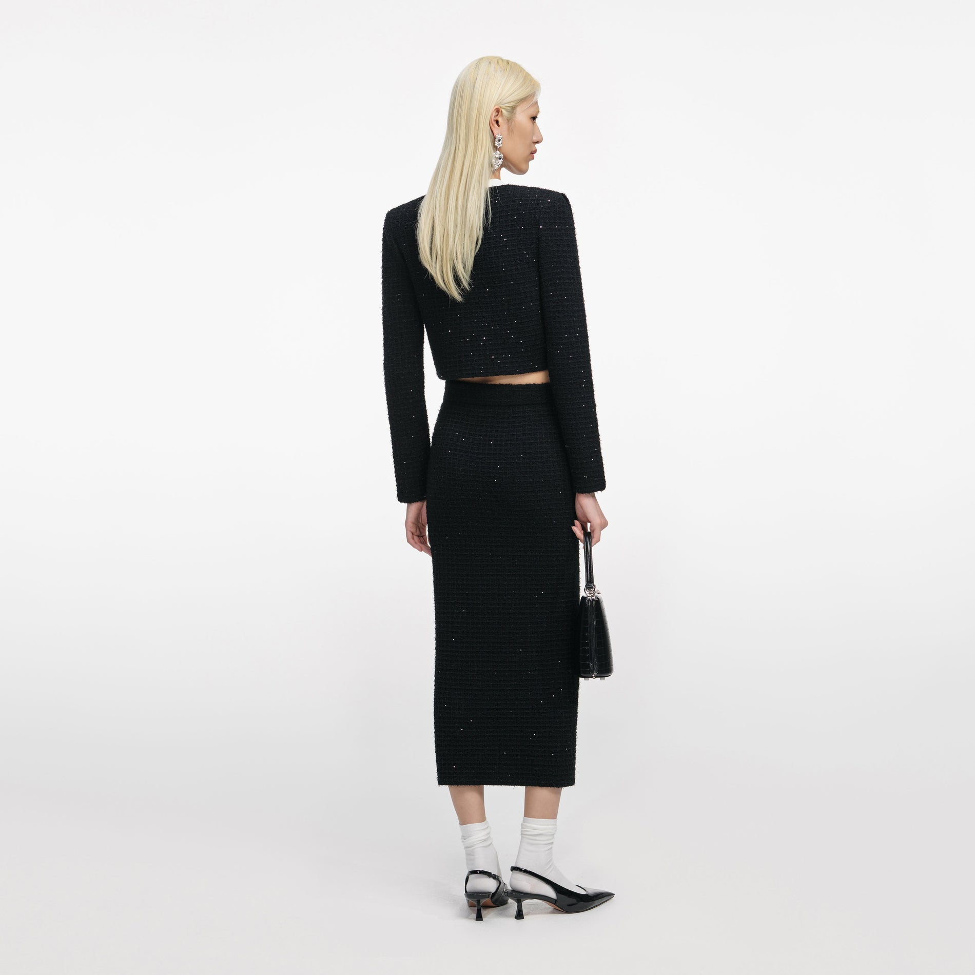 Back view of a woman wearing the Black Floral Textured Knit Jacket