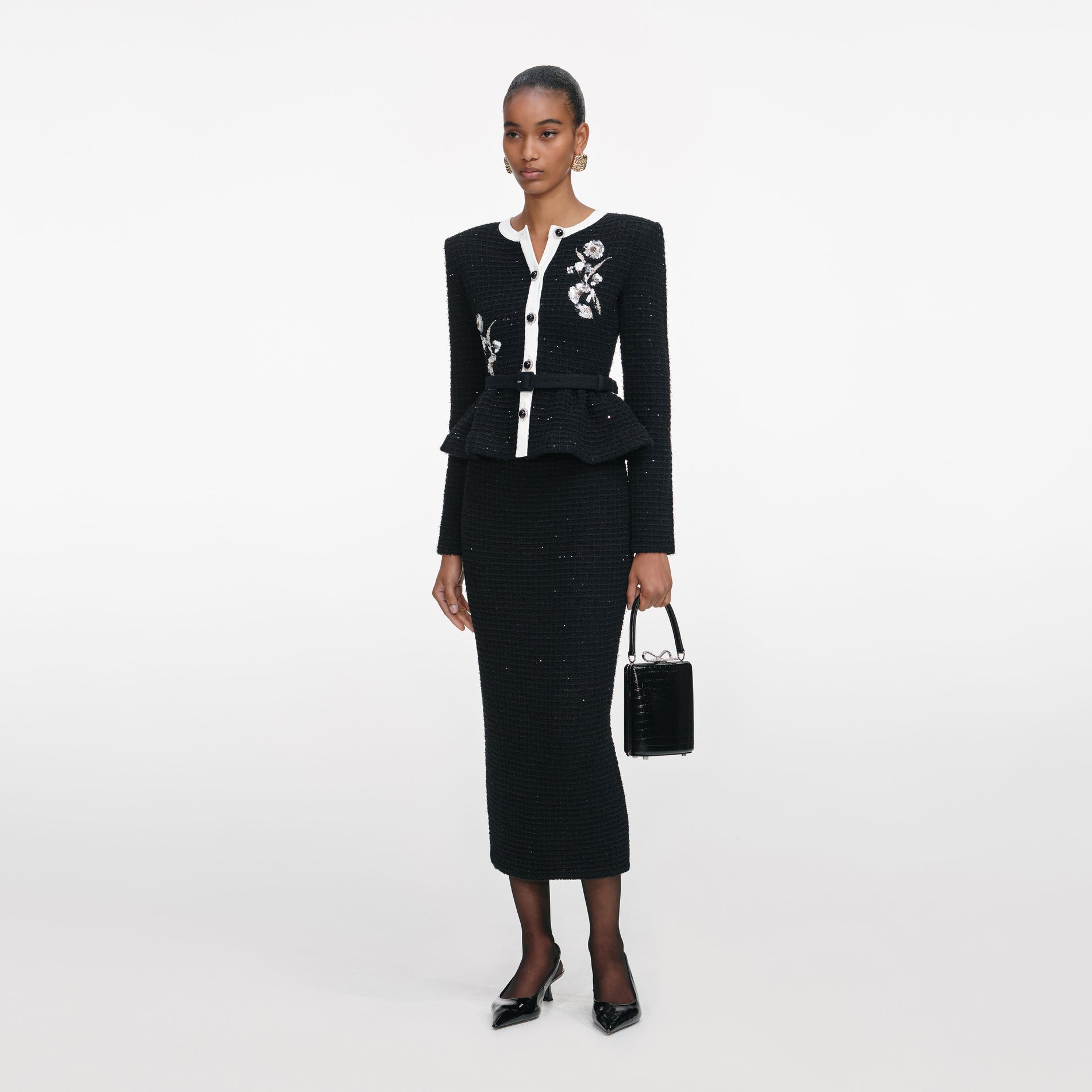 Side view of a woman wearing the Black Floral Textured Knit Midi Dress