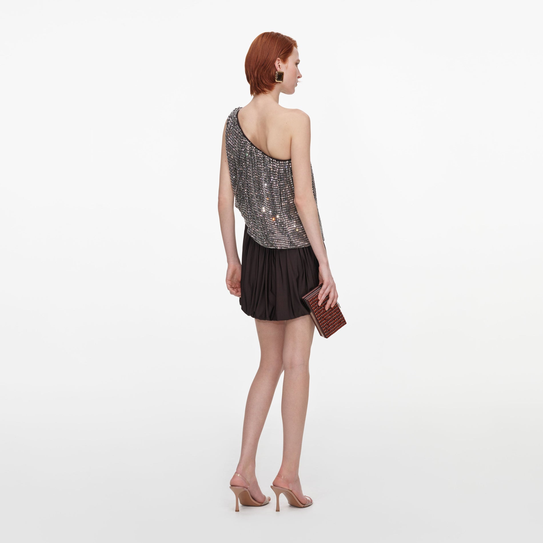 Back view of a woman wearing the Rhinestone One Shoulder Drape Mini Dress