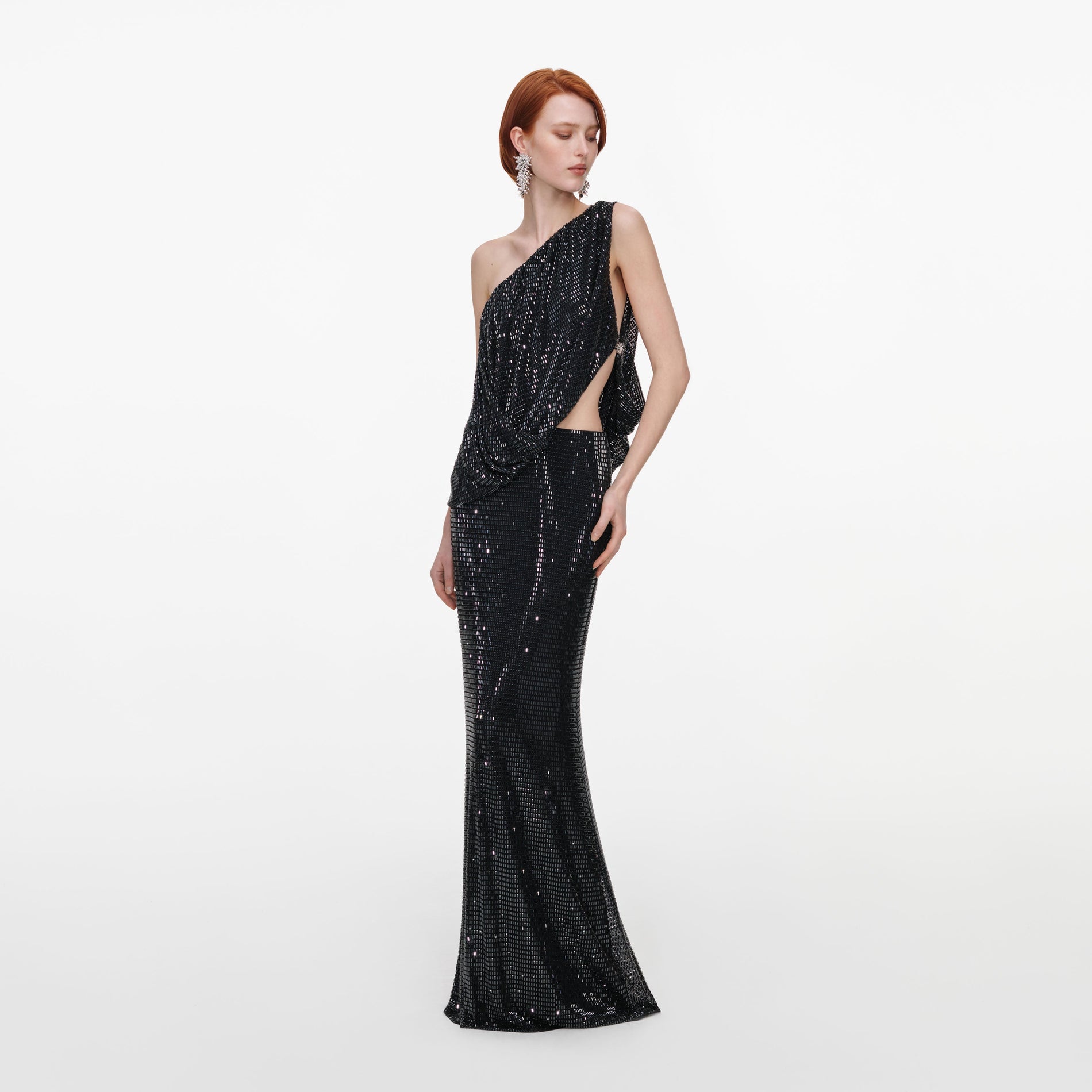 Side view of a woman wearing the Black Rhinestone One Shoulder Drape Maxi Dress