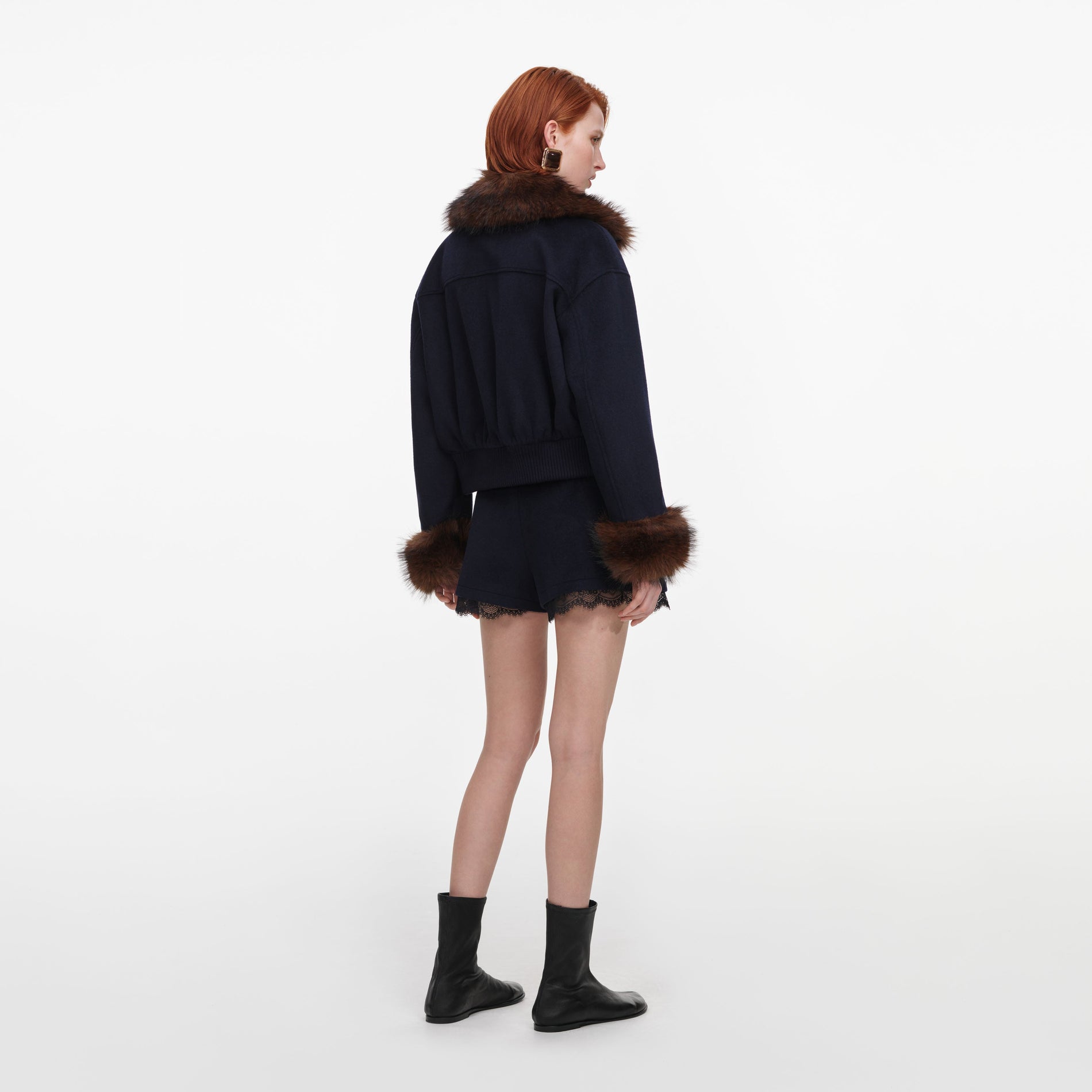 Back view of a woman wearing the Navy Wool Fur Trim Jacket