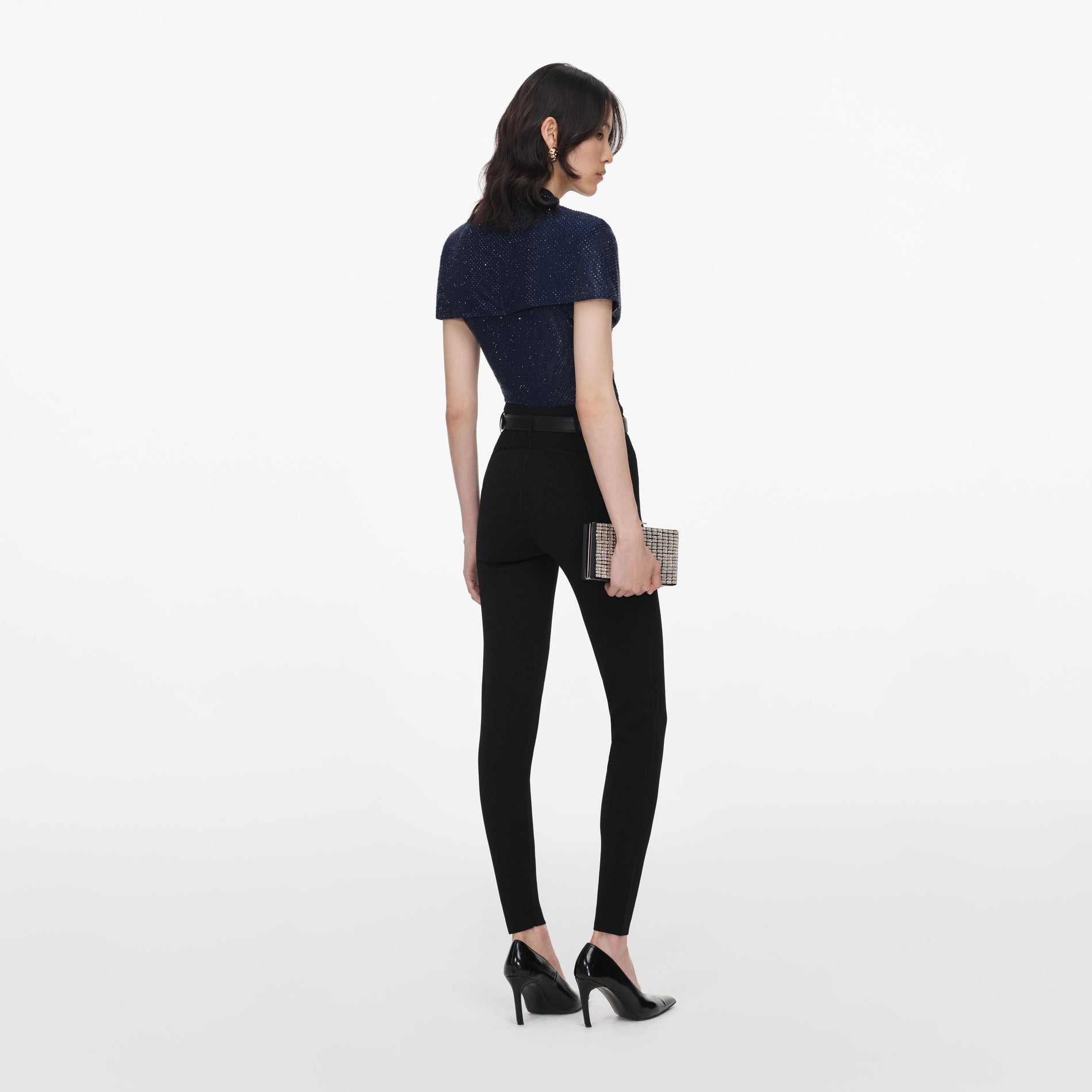 Back view of a woman wearing the Navy Rhinestone Mesh Cut Out Top