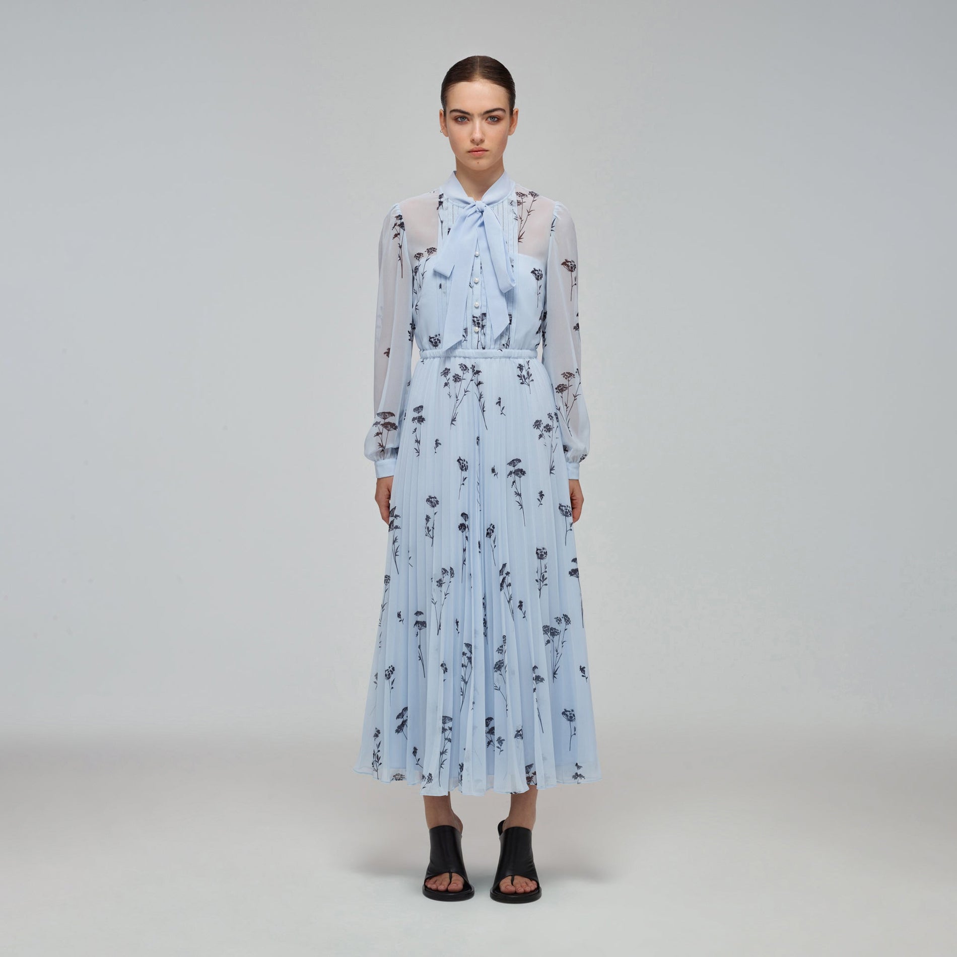 A woman wearing the Blue Floral Silhouette Chiffon Midi Dress