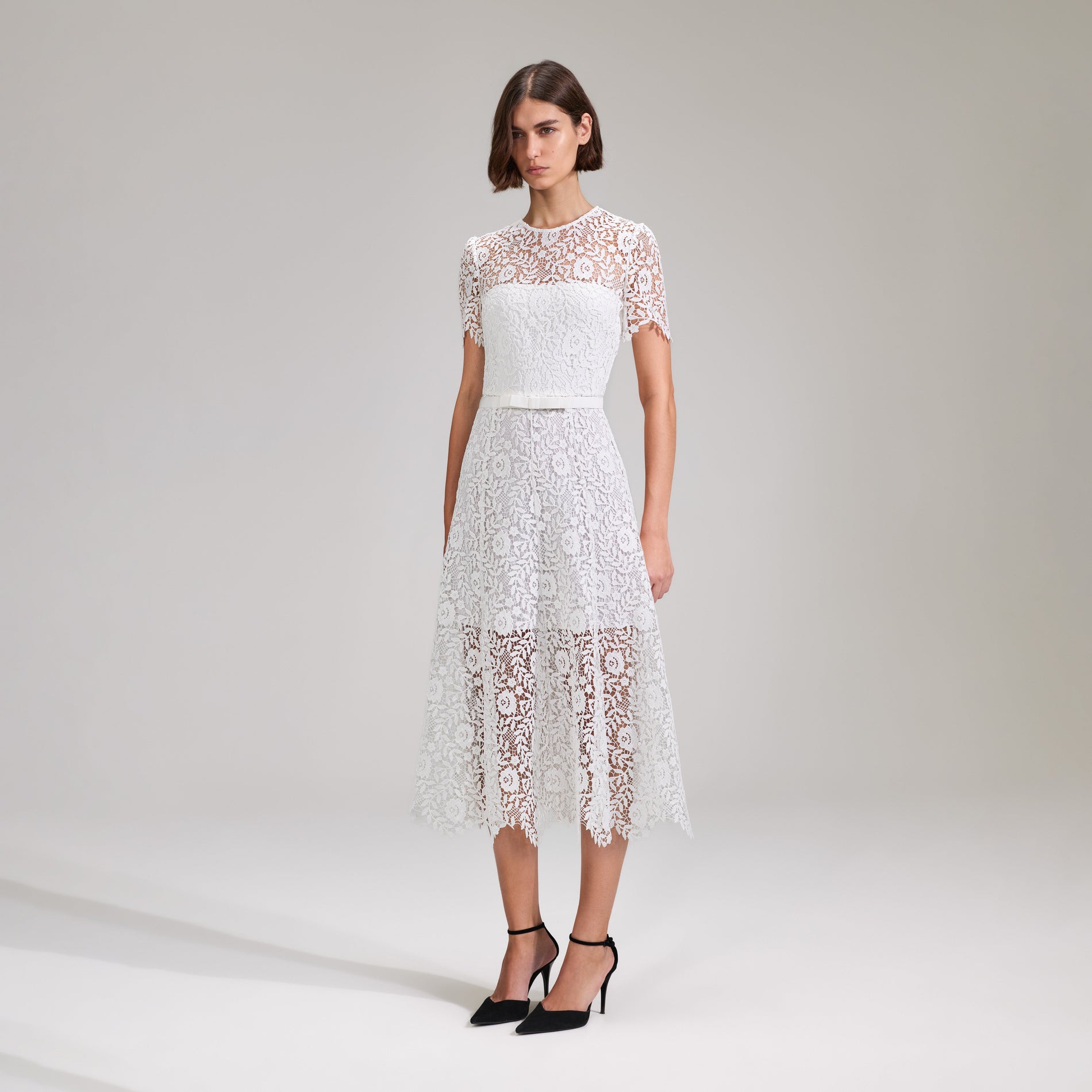 A woman wearing the White Rose Lace Midi Dress