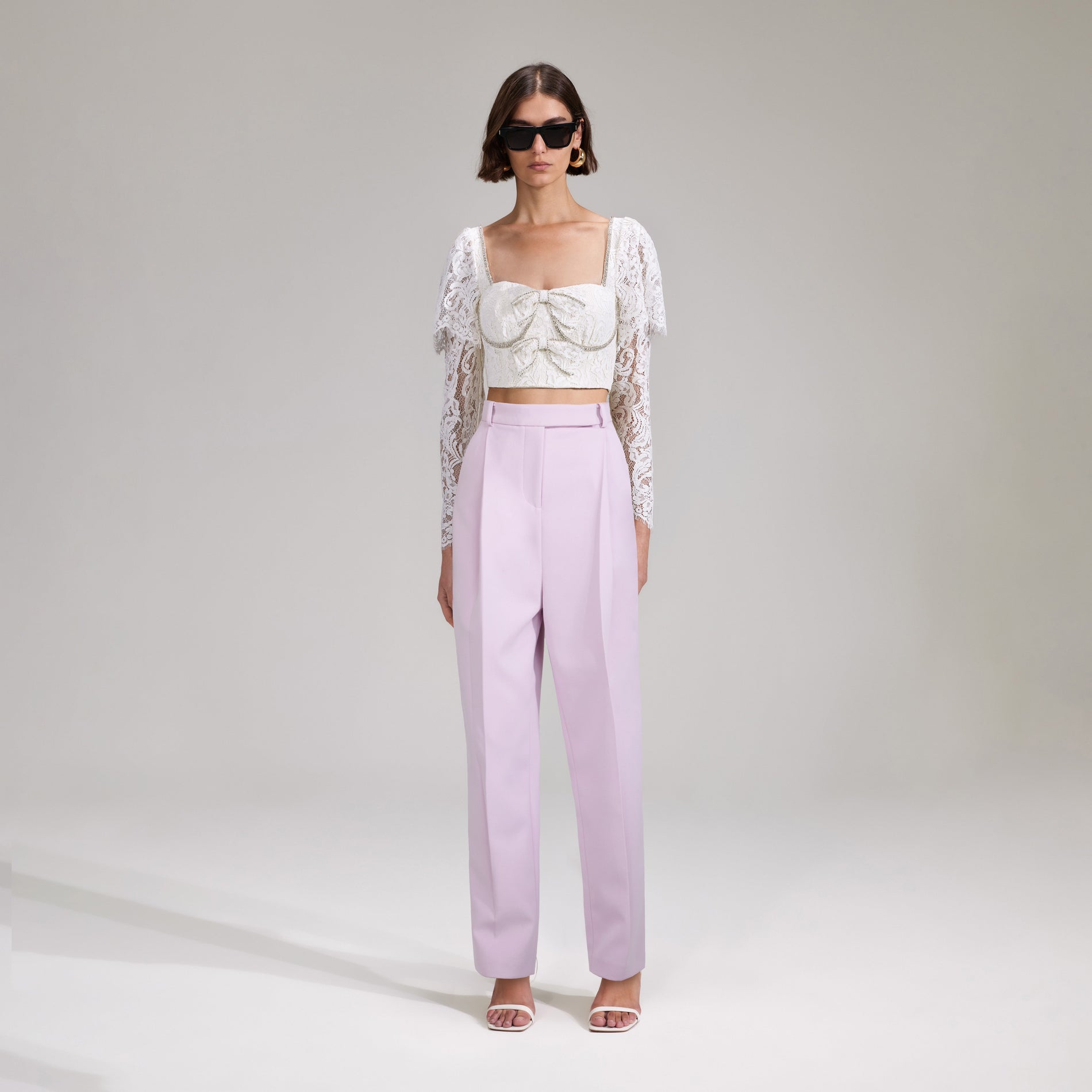 A woman wearing the Cream Cord Lace Cropped Top
