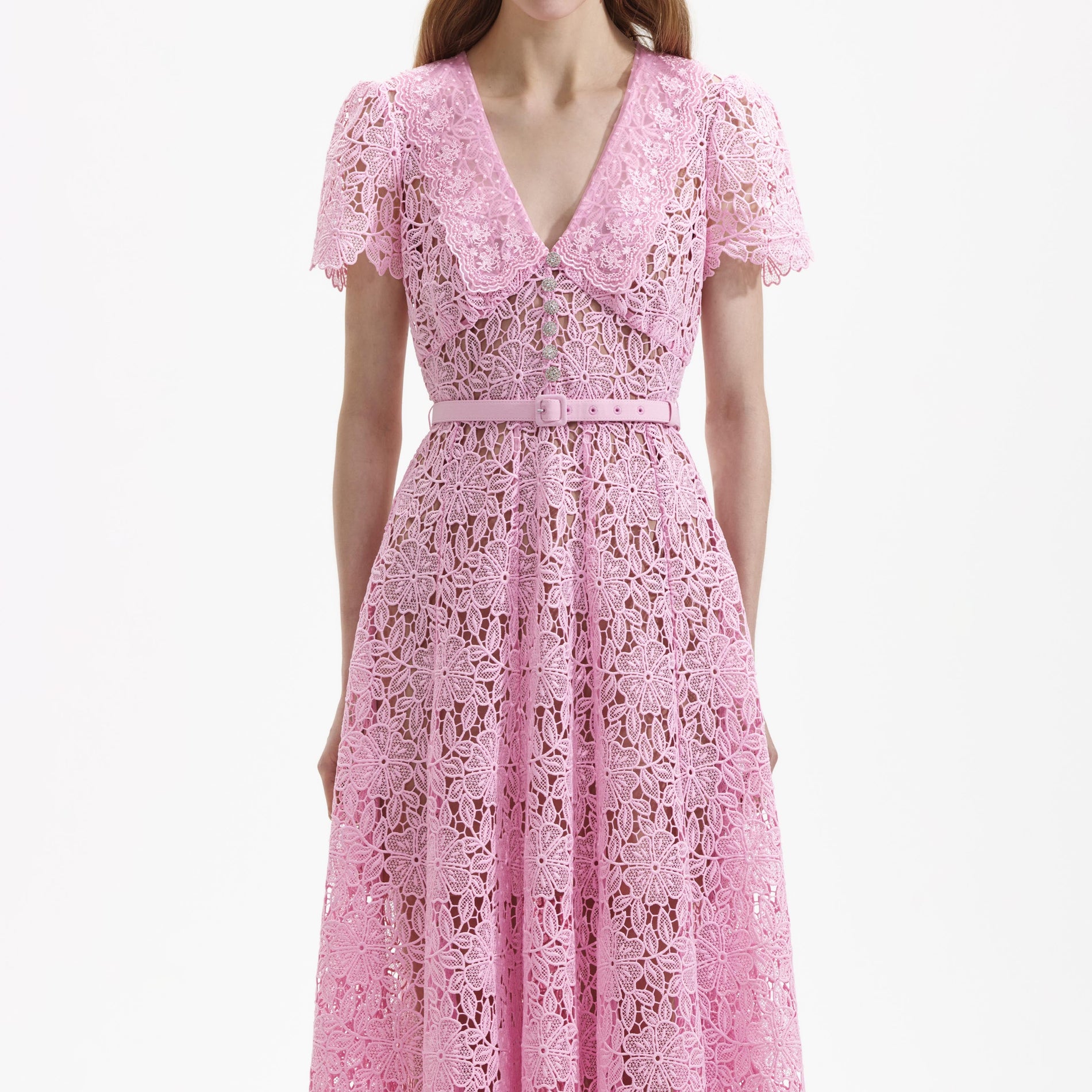 A close up of a woman wearing the Pink Guipure Midi Dress