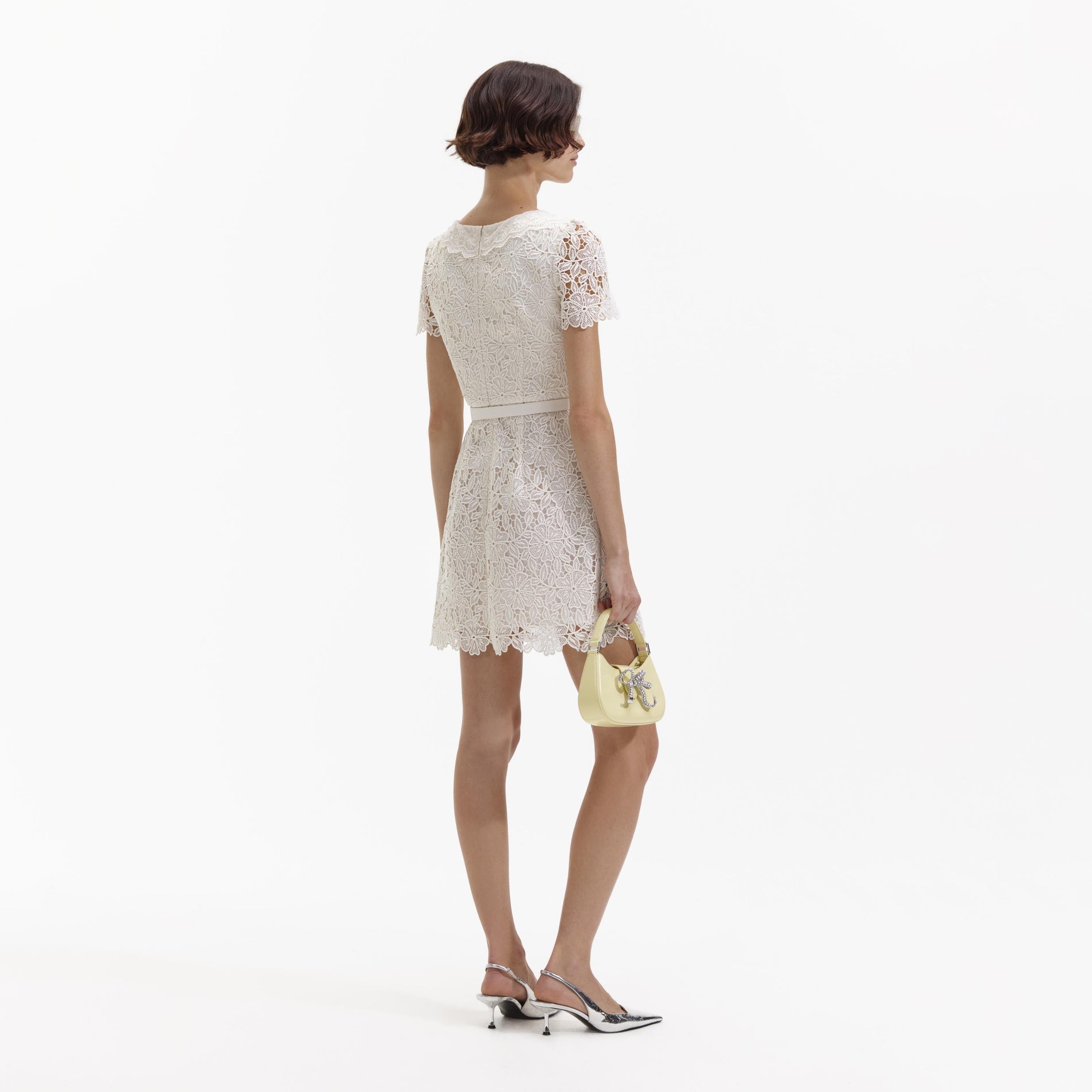 Back view of a woman wearing the Cream Guipure Lace Button Mini Dress