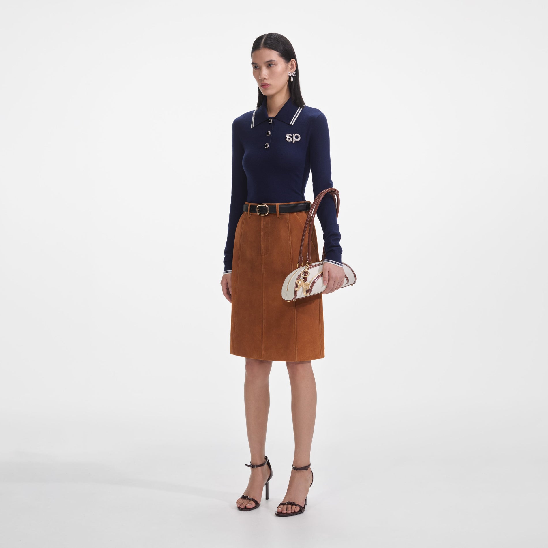 Side view of a woman wearing the Navy Knit Long Sleeve SP Polo Top