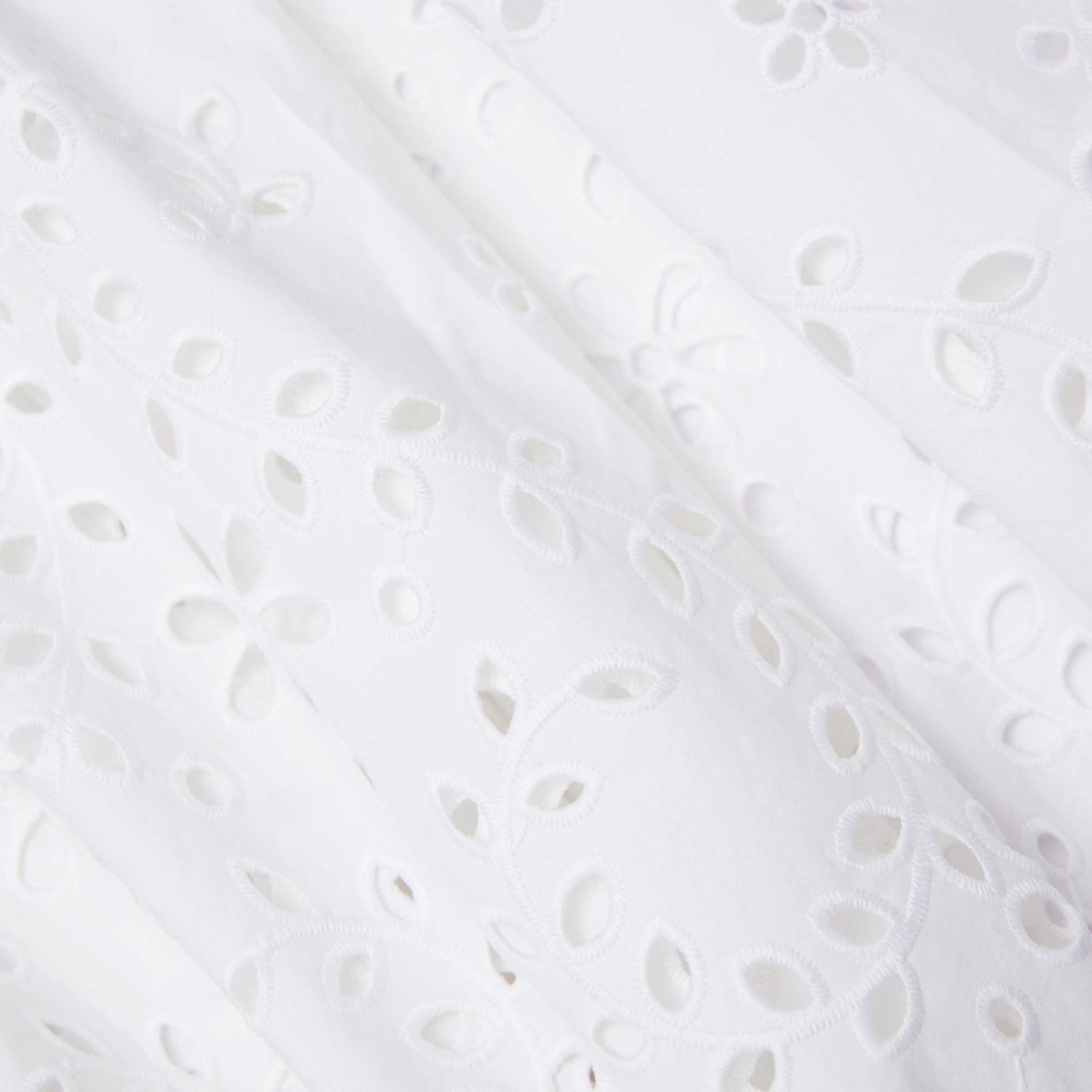 Side view of a woman wearing the White Cotton Embroidered Midi Skirt