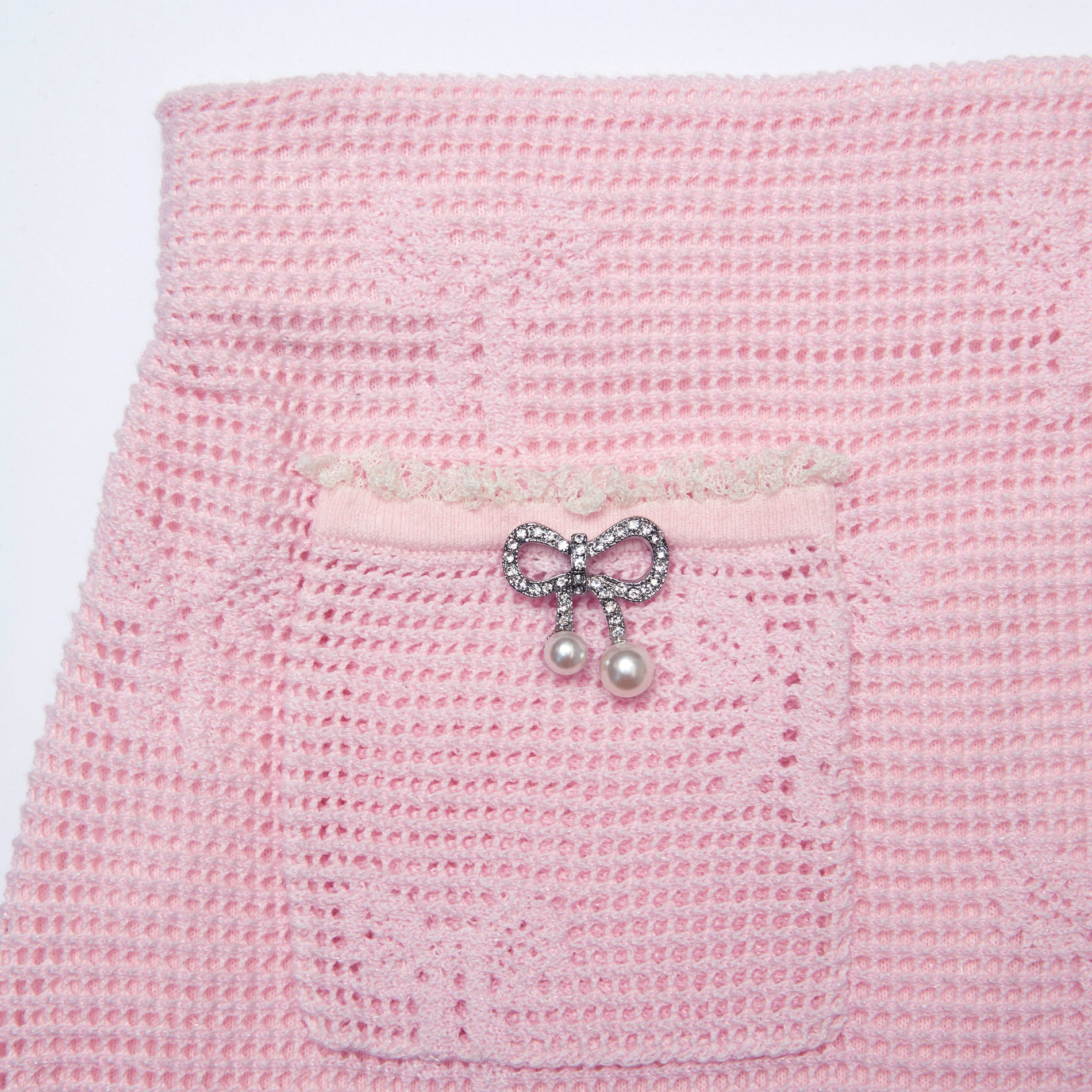 Side view of a woman wearing the Pink Bow Crochet Mini Skirt