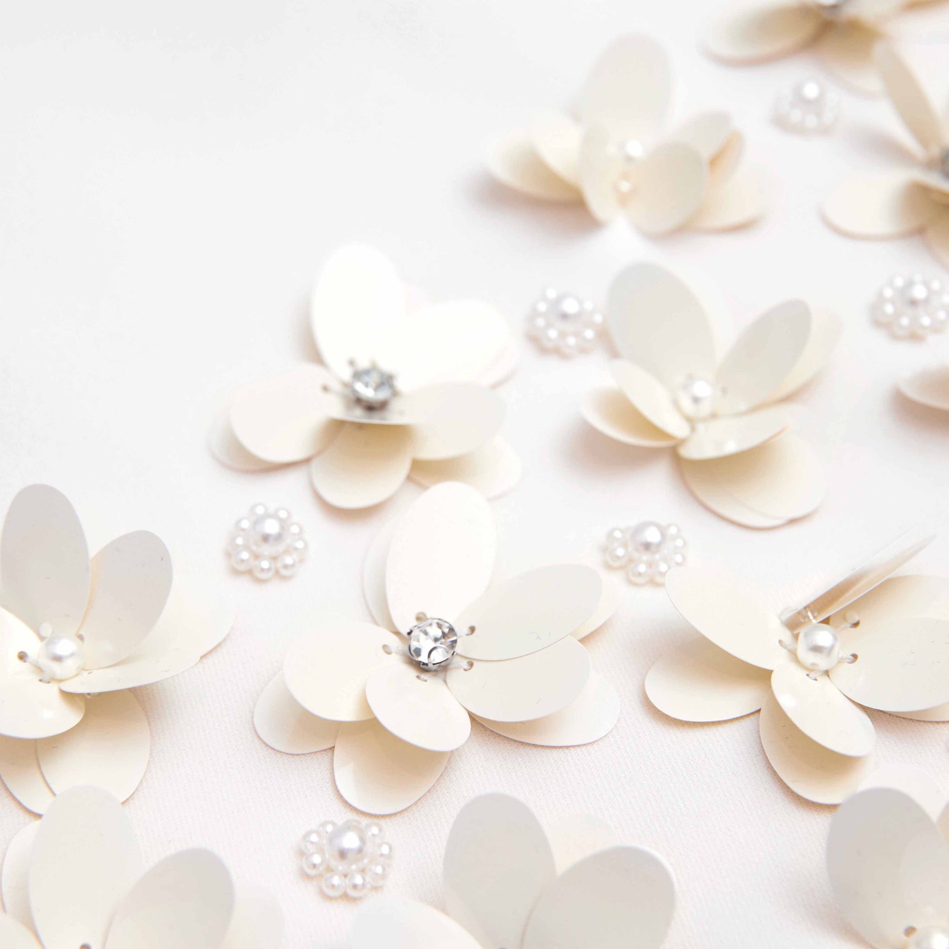 Side view of a woman wearing the Cream Crepe 3D Sequin Mini Dress