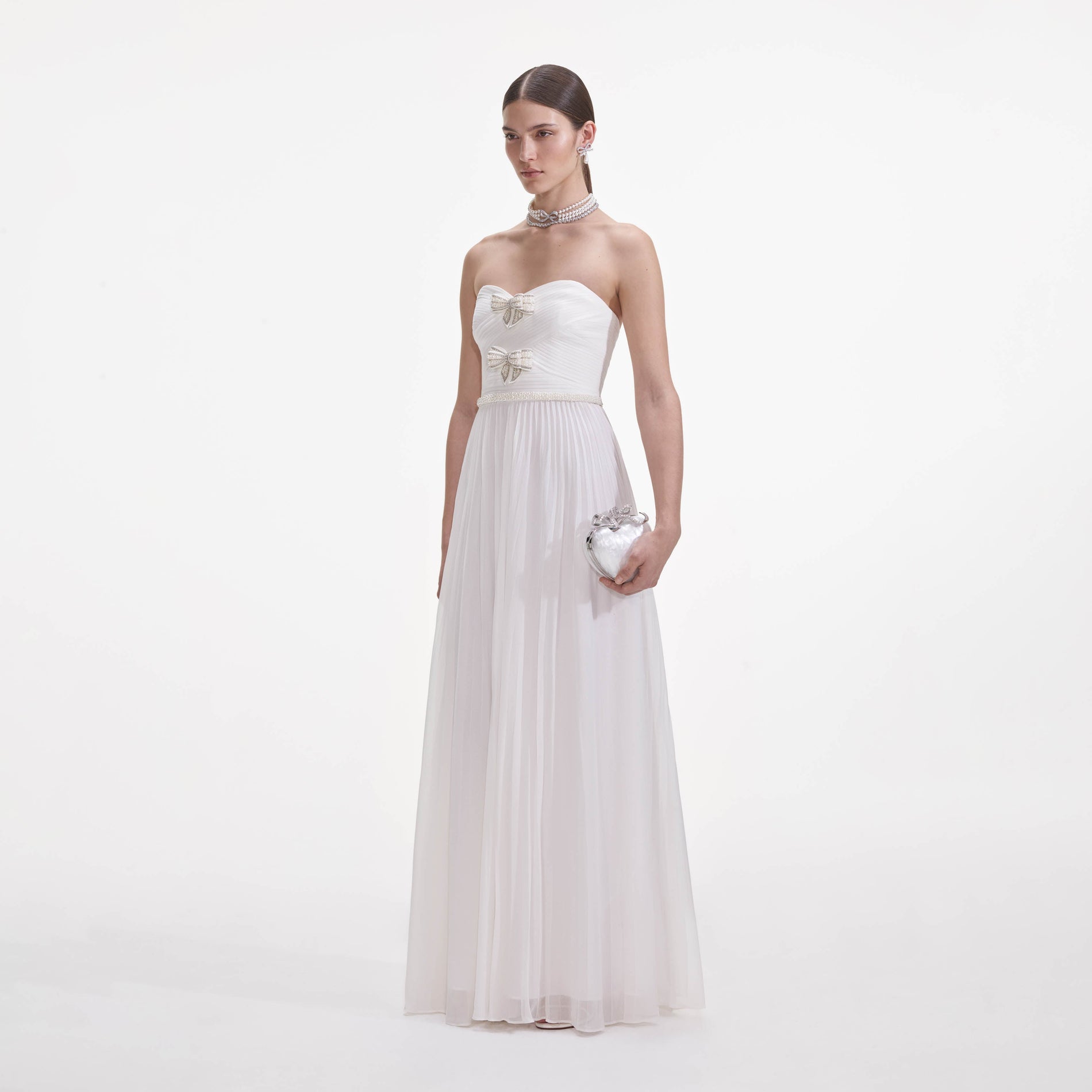 Side view of a woman wearing the White Chiffon Bow Maxi Dress