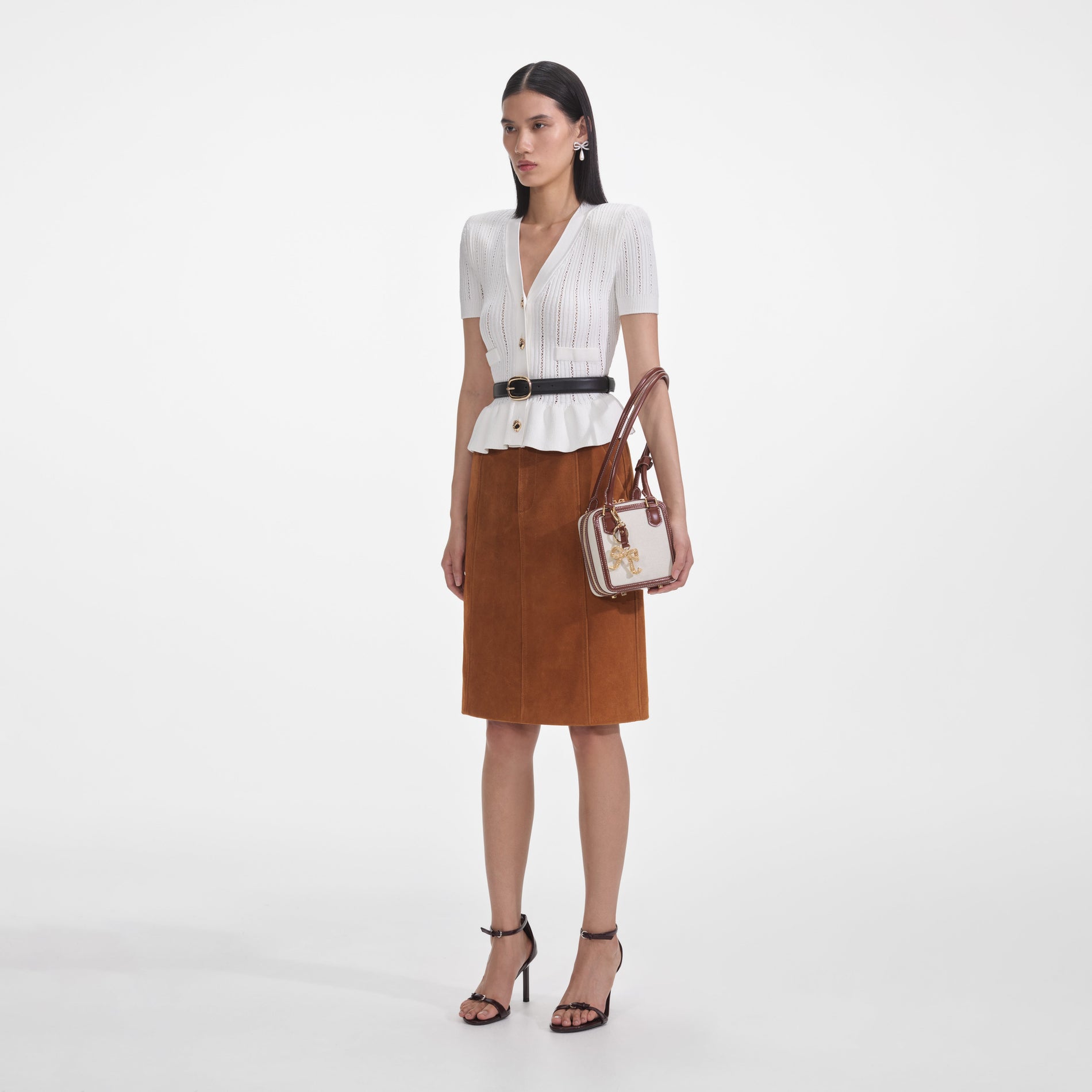 Side view of a woman wearing the White Peplum Knit Top