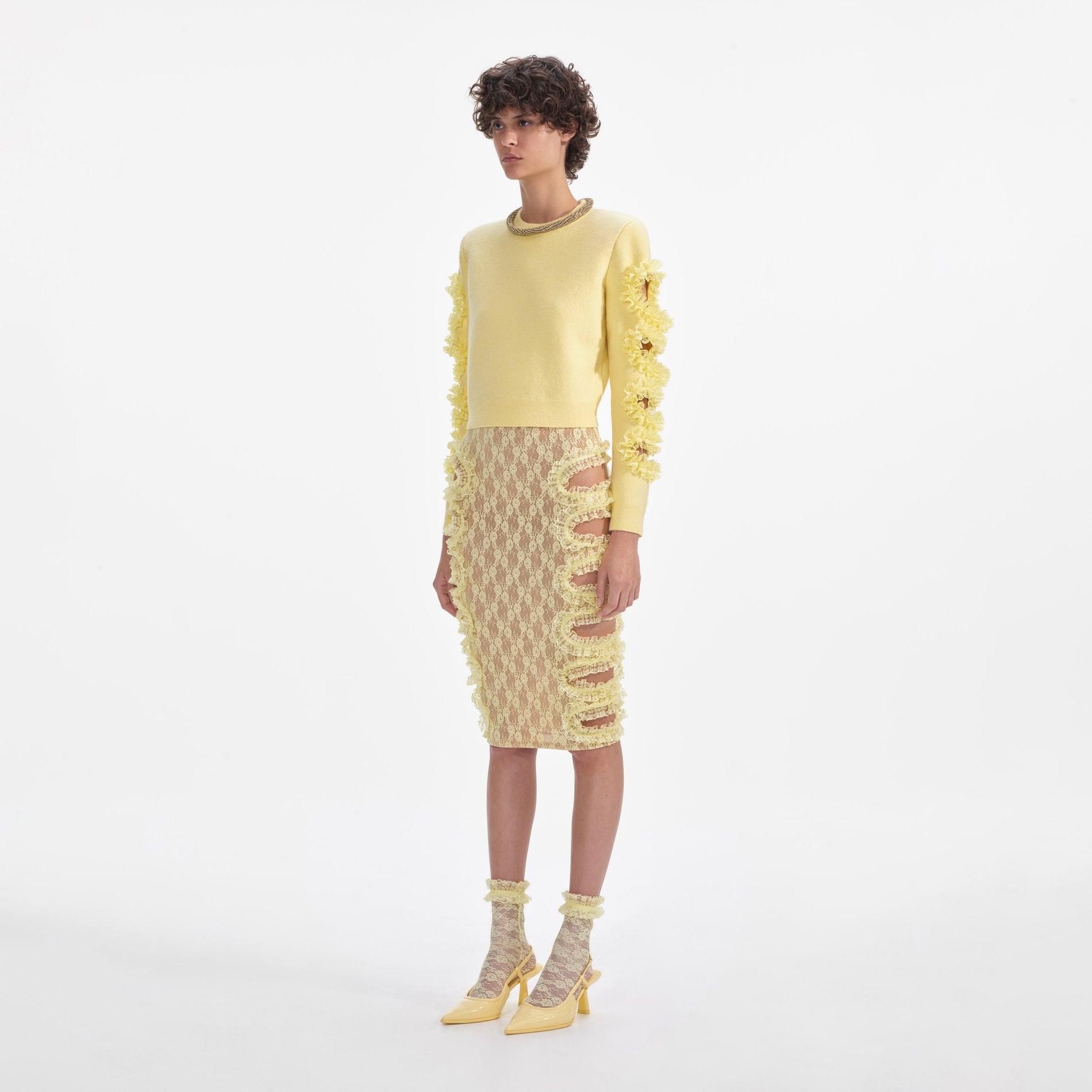 Side view of a woman wearing the Yellow Lace Cut Out Midi Skirt