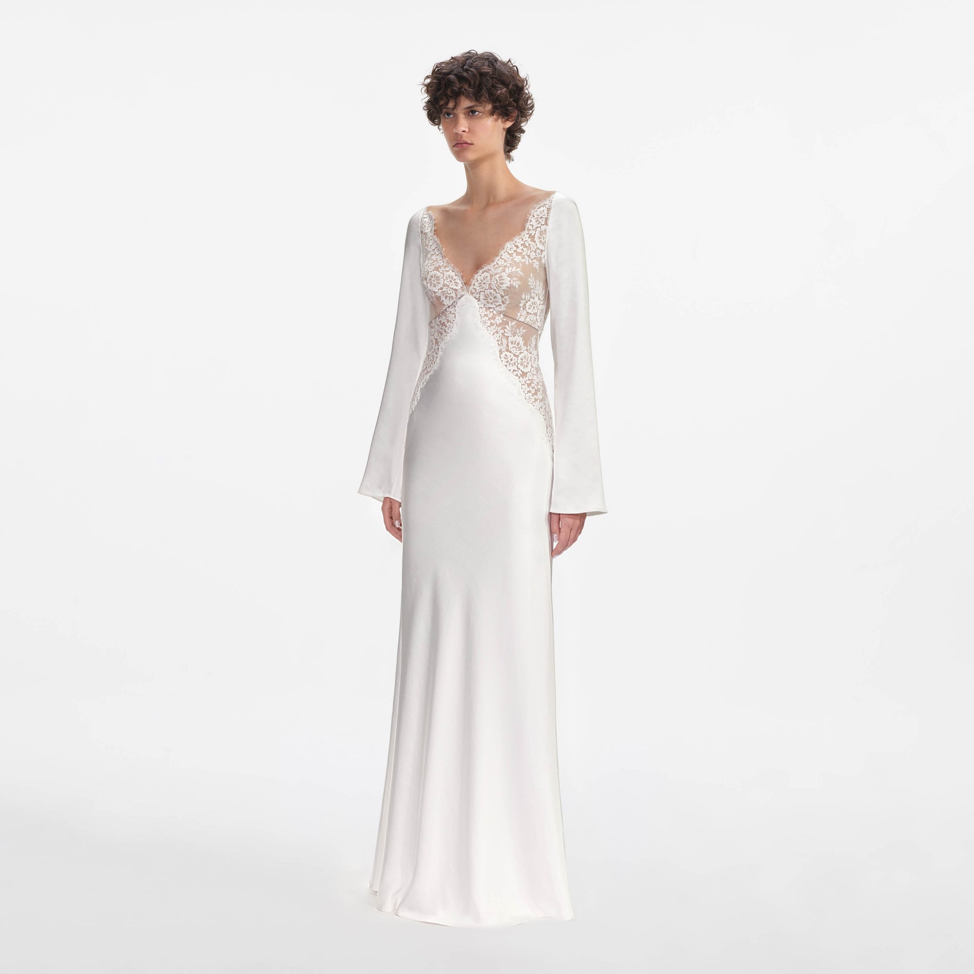 Side view of a woman wearing the White Lace Satin Long Sleeve Maxi Dress