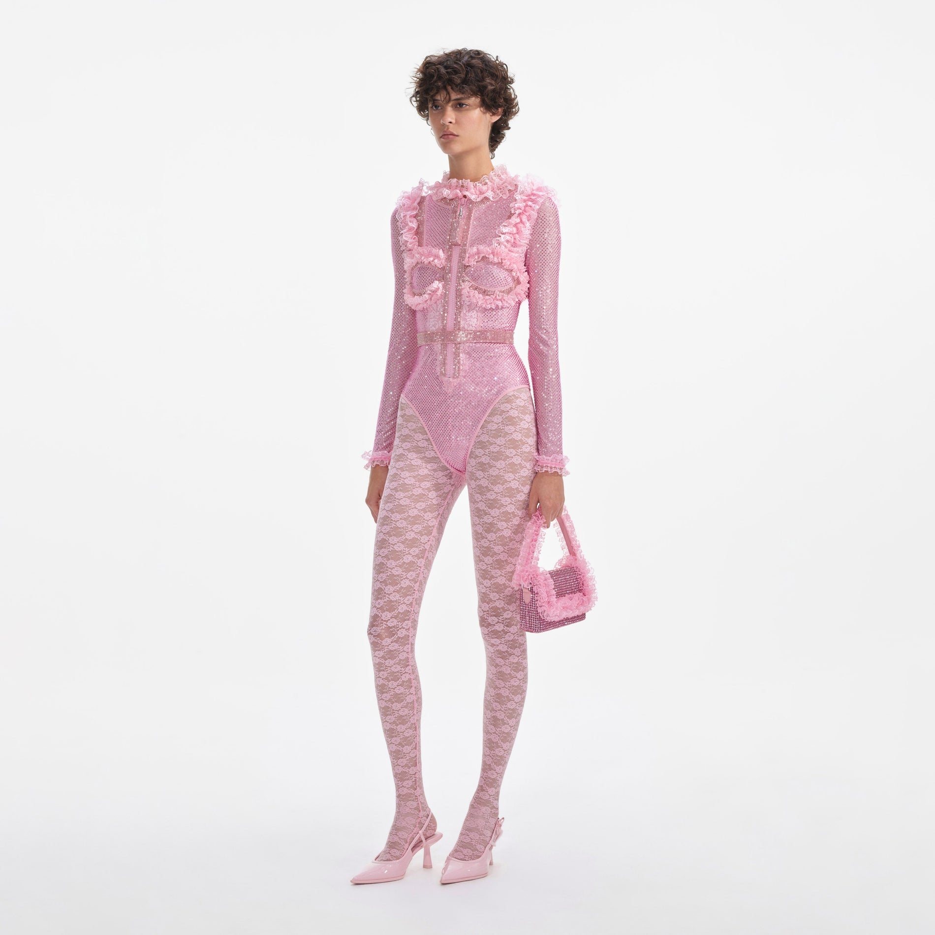 Side view of a woman wearing the Pink Rhinestone Mesh Ruffle Bodysuit